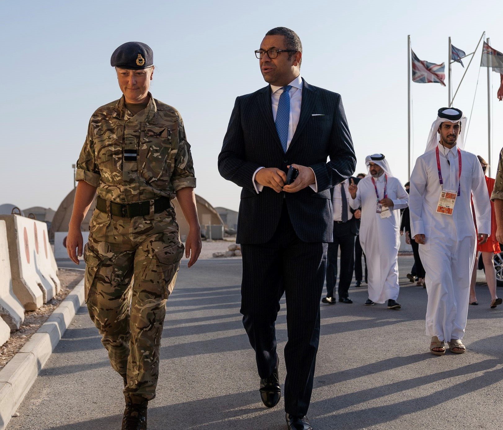 Image shows RAF aviator walking with civilians wearing middle eastern attire.