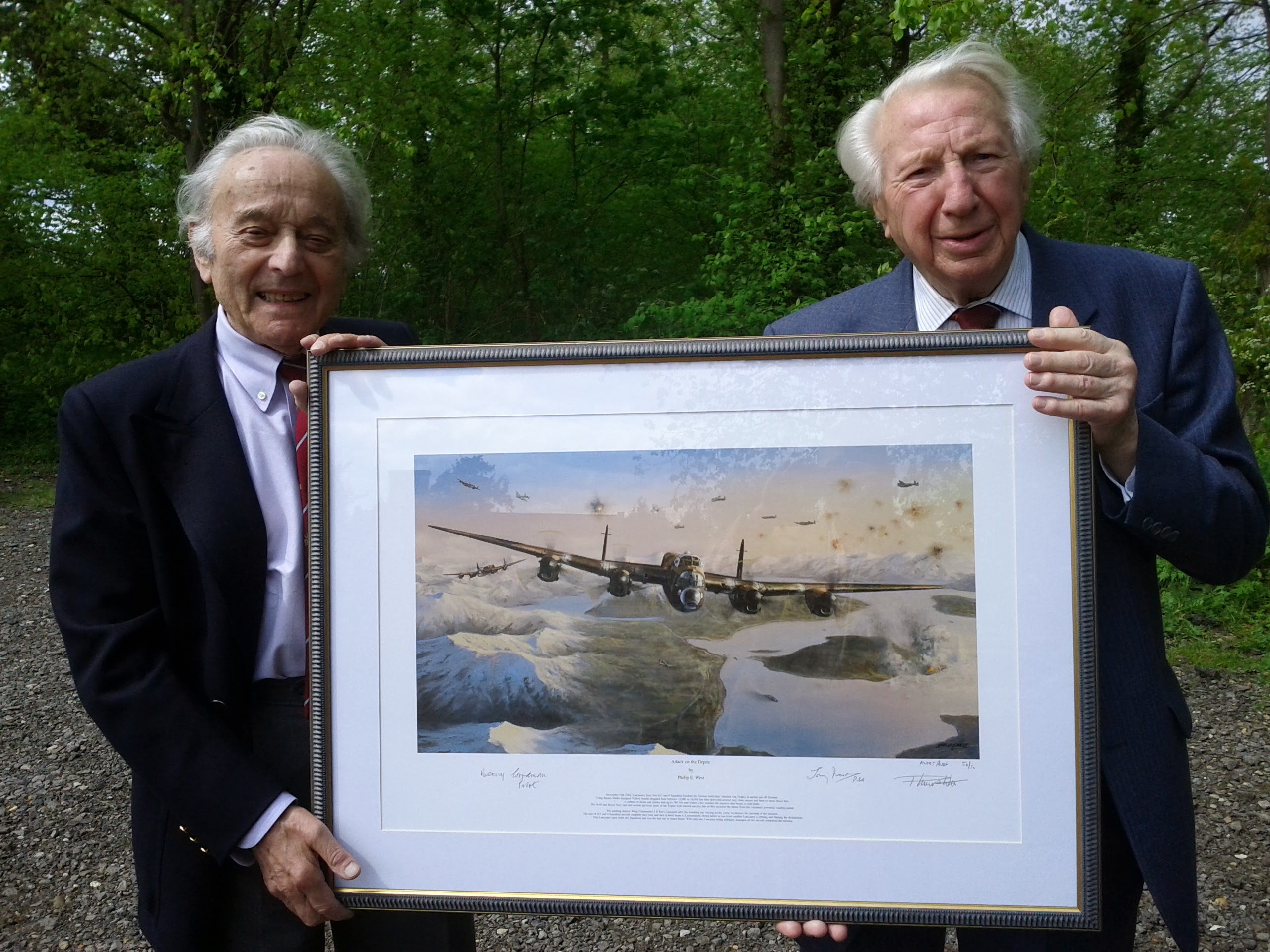 Benny and friend hold a framed picture of a Lancaster between them.