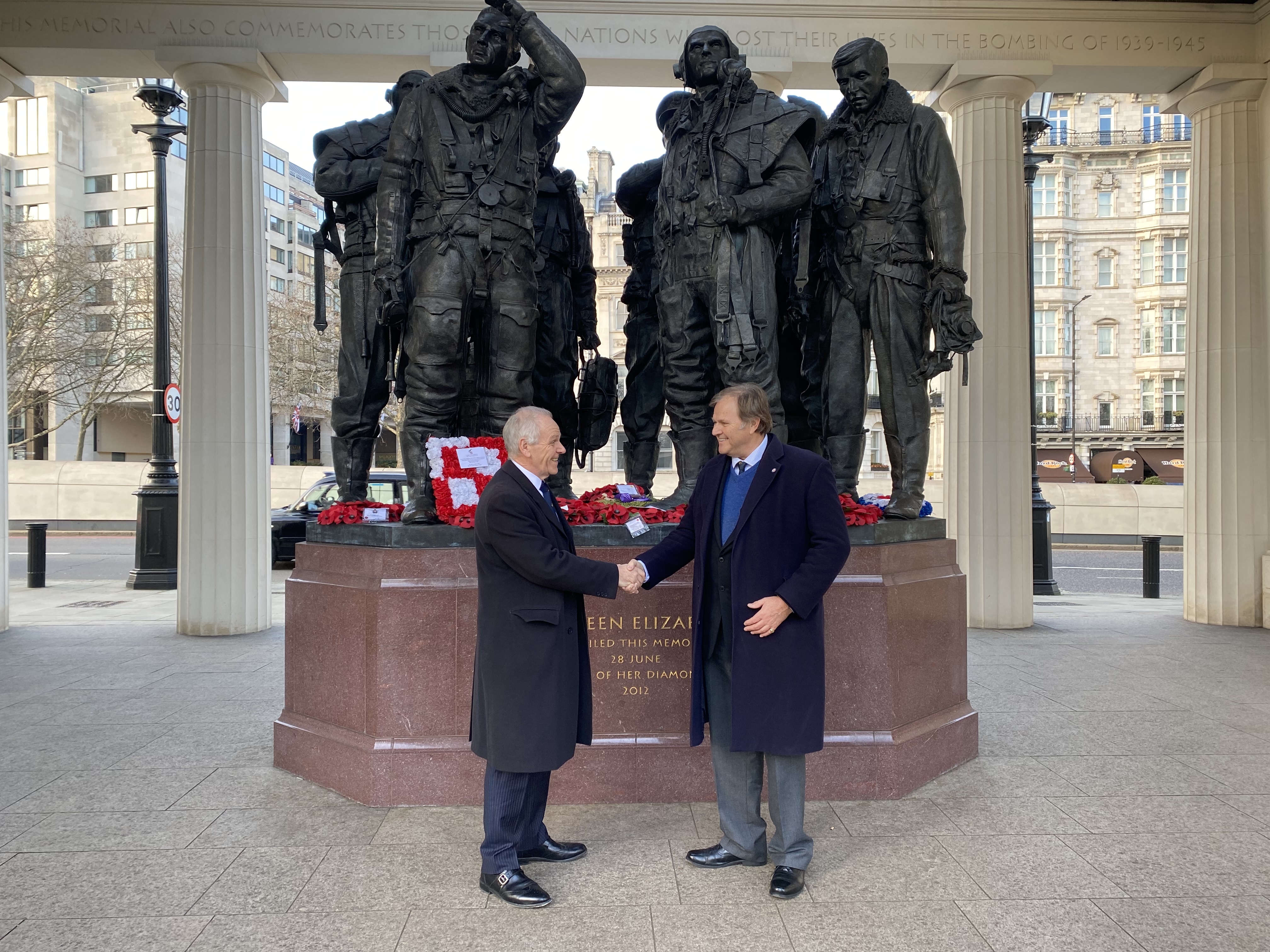  Lawrie Haynes and Richard Daniel shake hands outside a memorial statue.