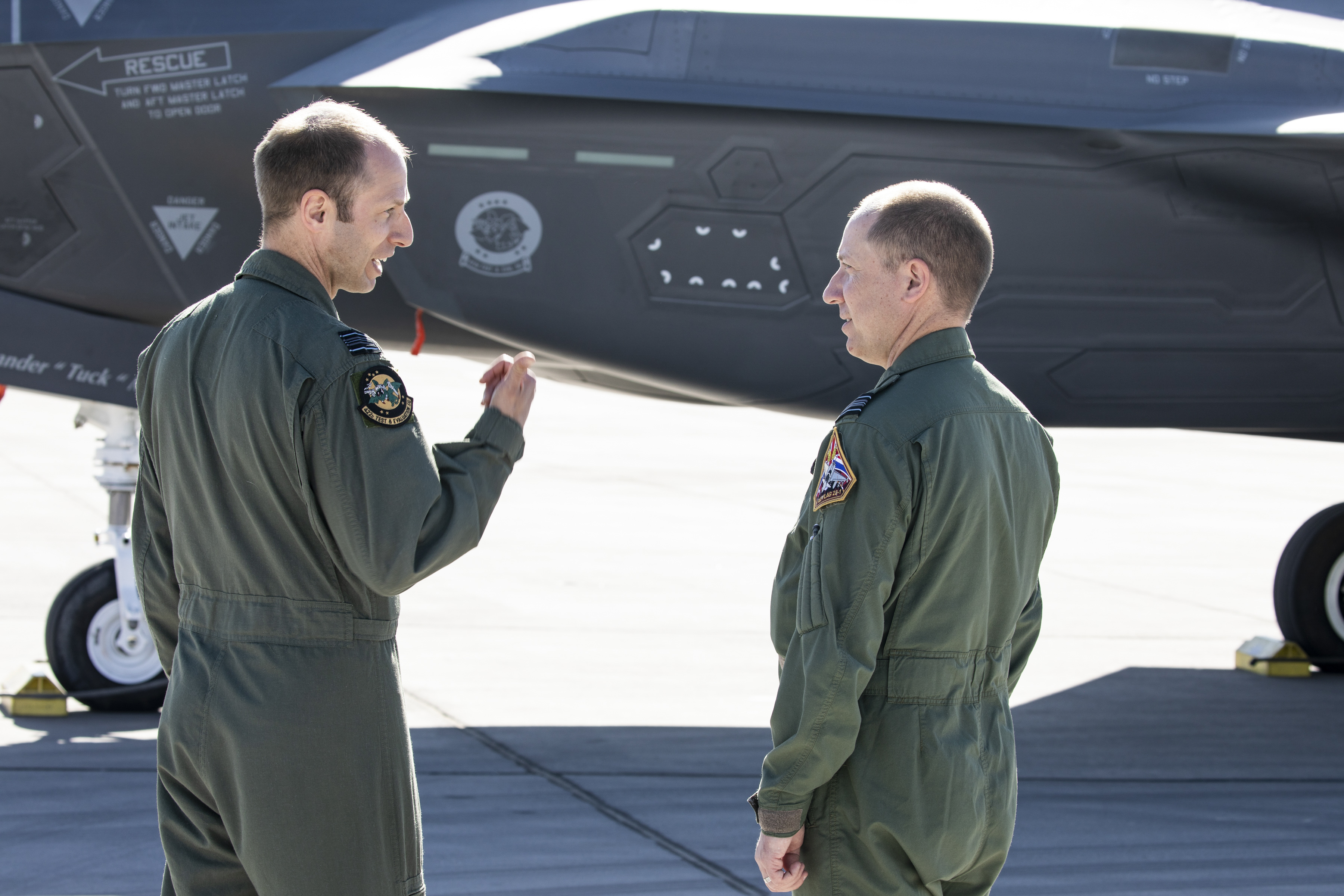 Two RAF Pilots on the airfield with a United States Air Force F-35 A jet.