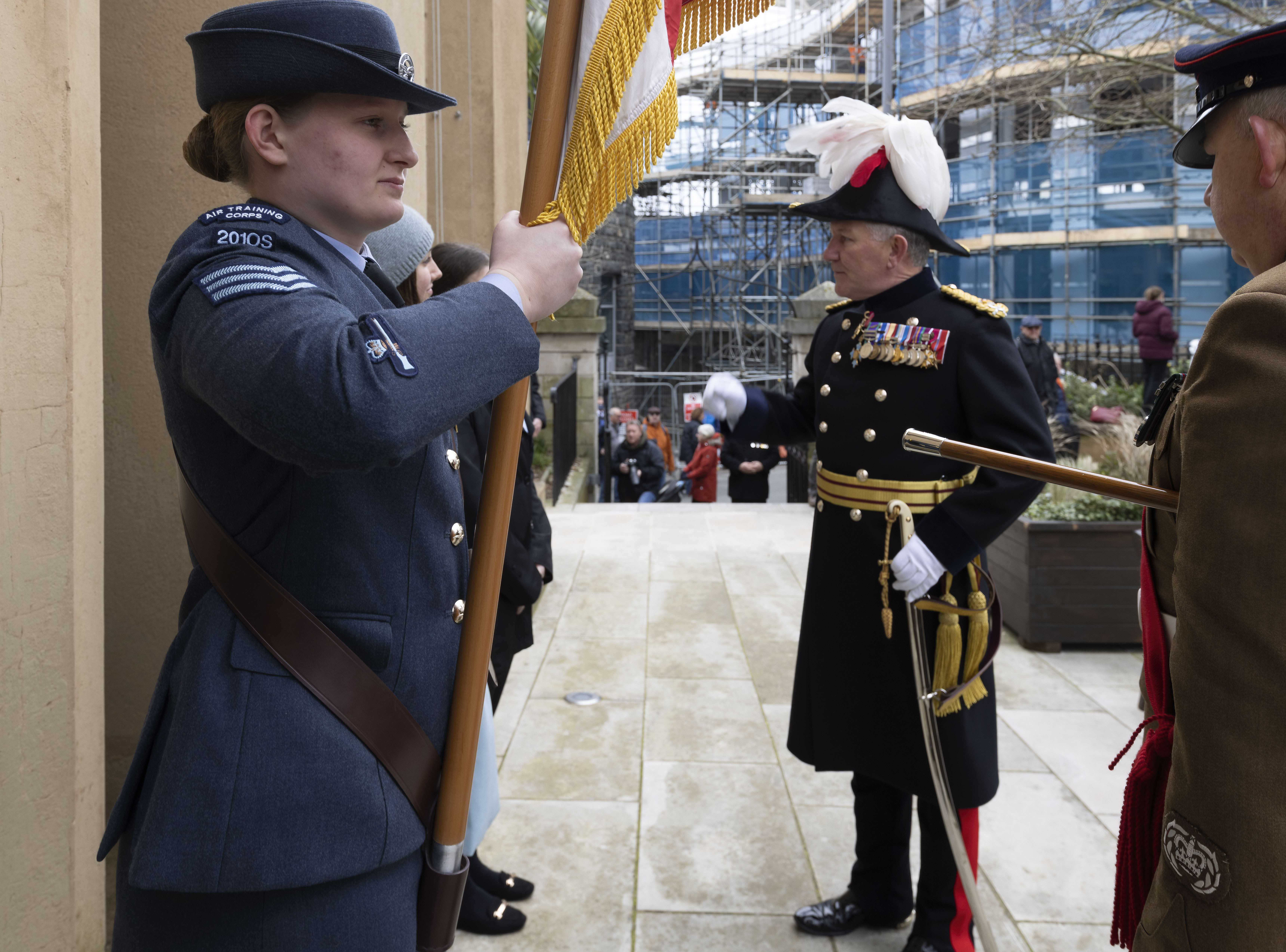 Personnel holds Colour Flag with Lieutenant-Governor of Guernsey in uniform.