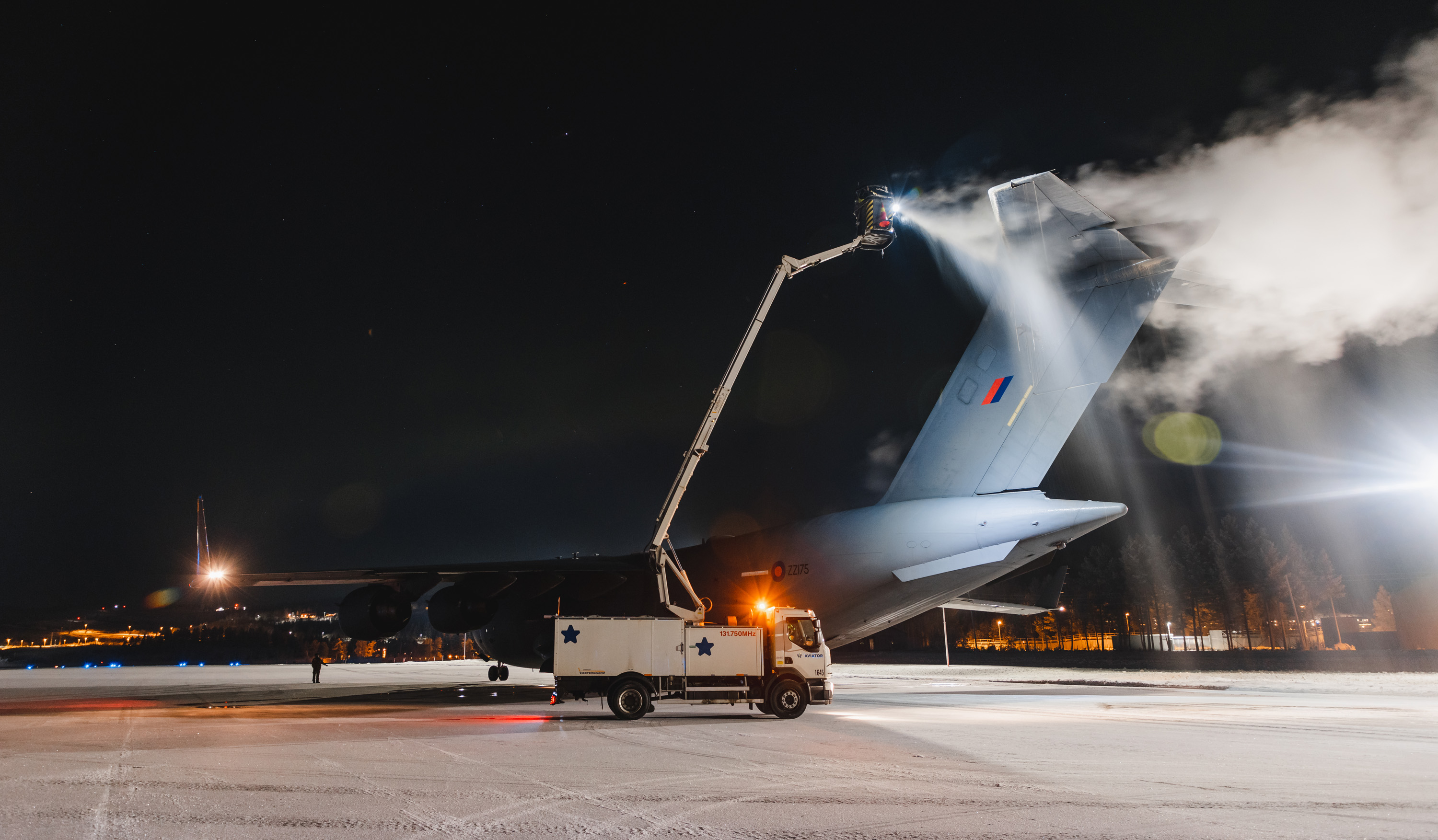 Image shows RAF Globemaster on the airfield, being de-iced by truck.