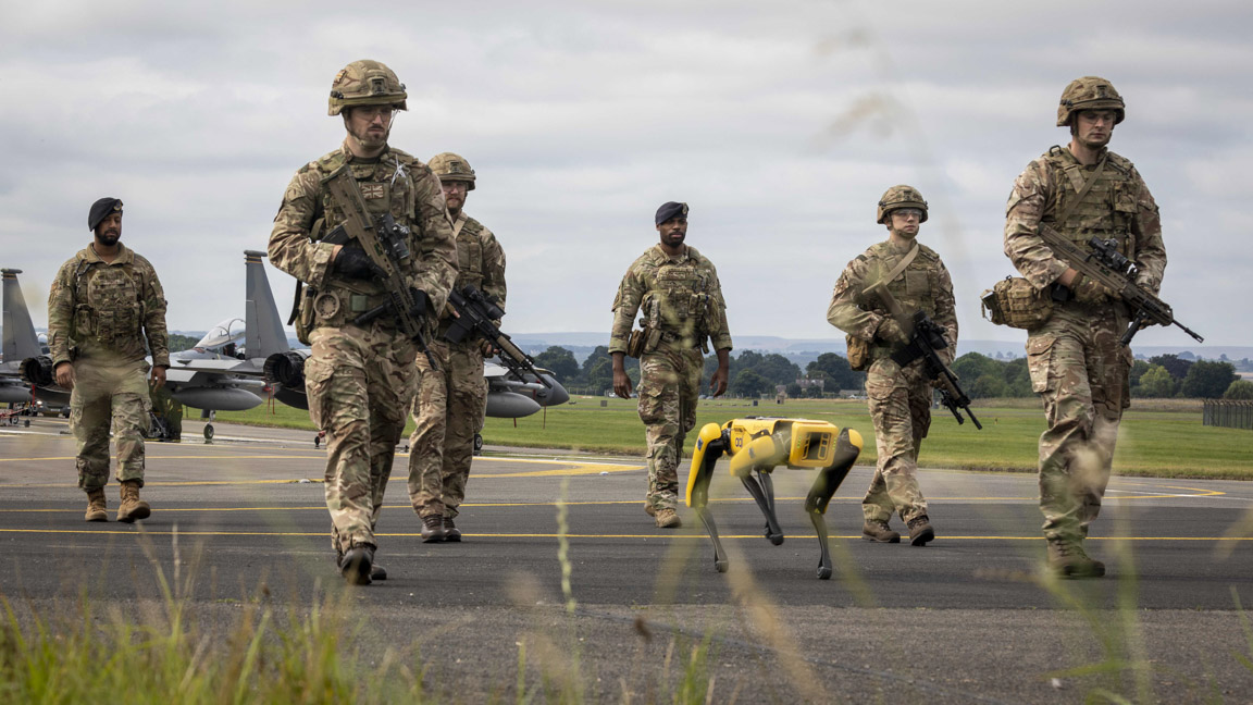 Personnel on the airfield with Spot the robot dog.