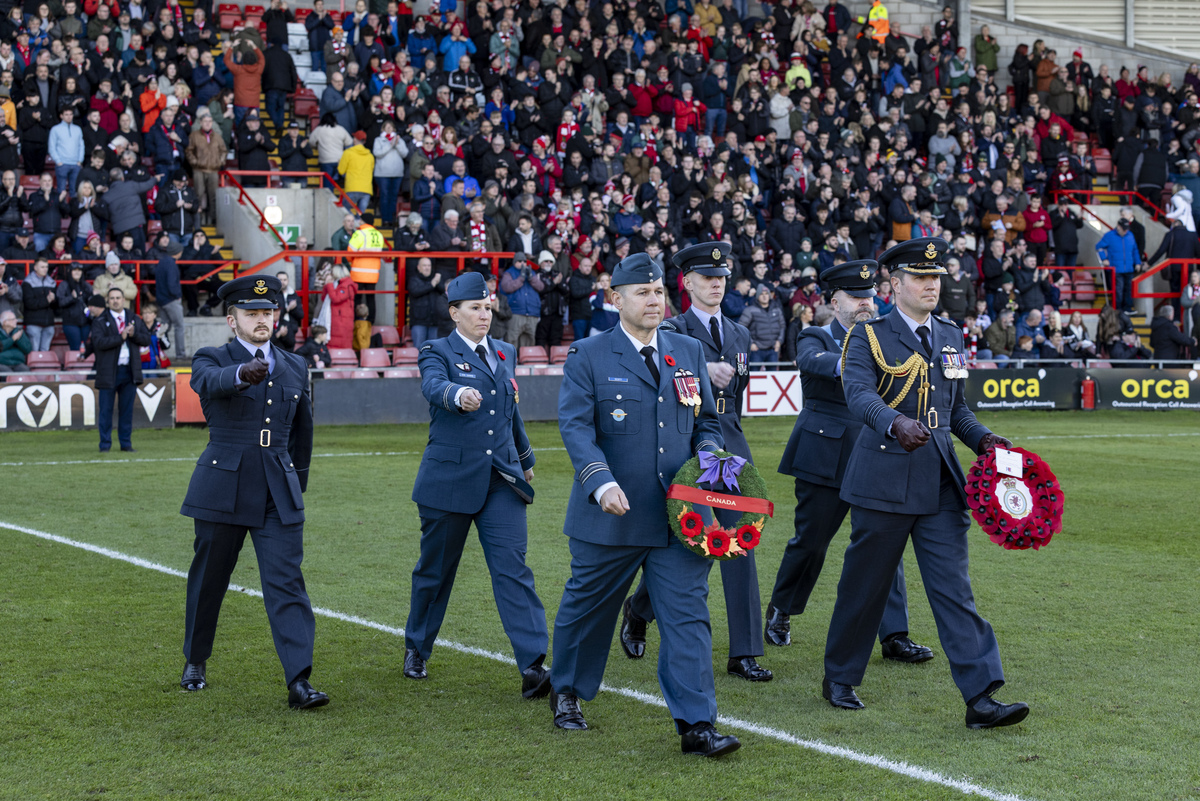 RAF personnel marching onto the football pitch for Remembrance 