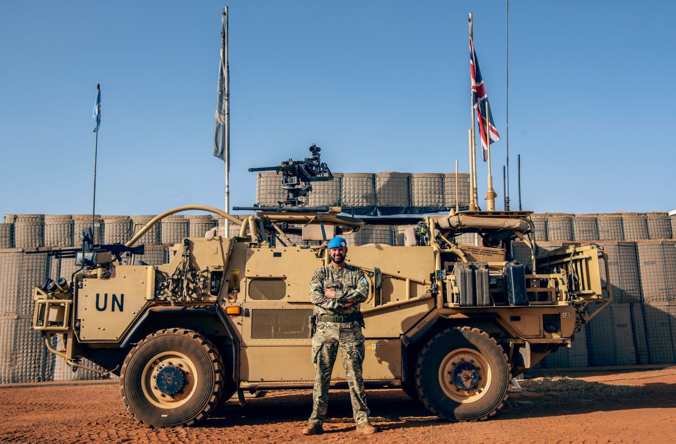 Image shows Sergeant Ashford in front of a military vehicle. 