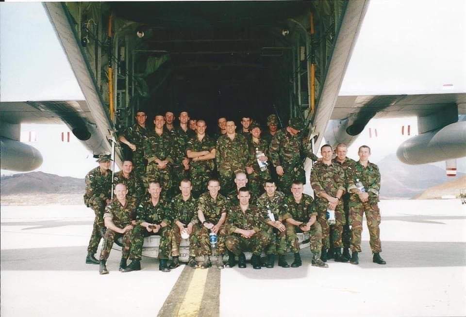 Image shows a group shot of RAF personnel on the ramp of an RAF Hercules aircraft.