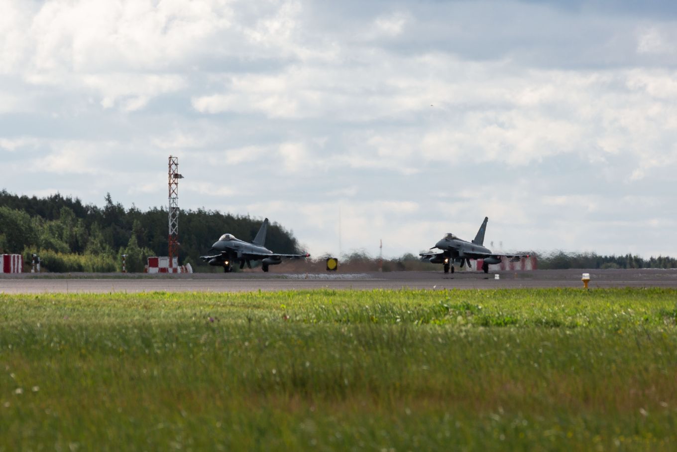 Image shows an RAF Typhoon and a German Eurofighter taxiing on the runway.