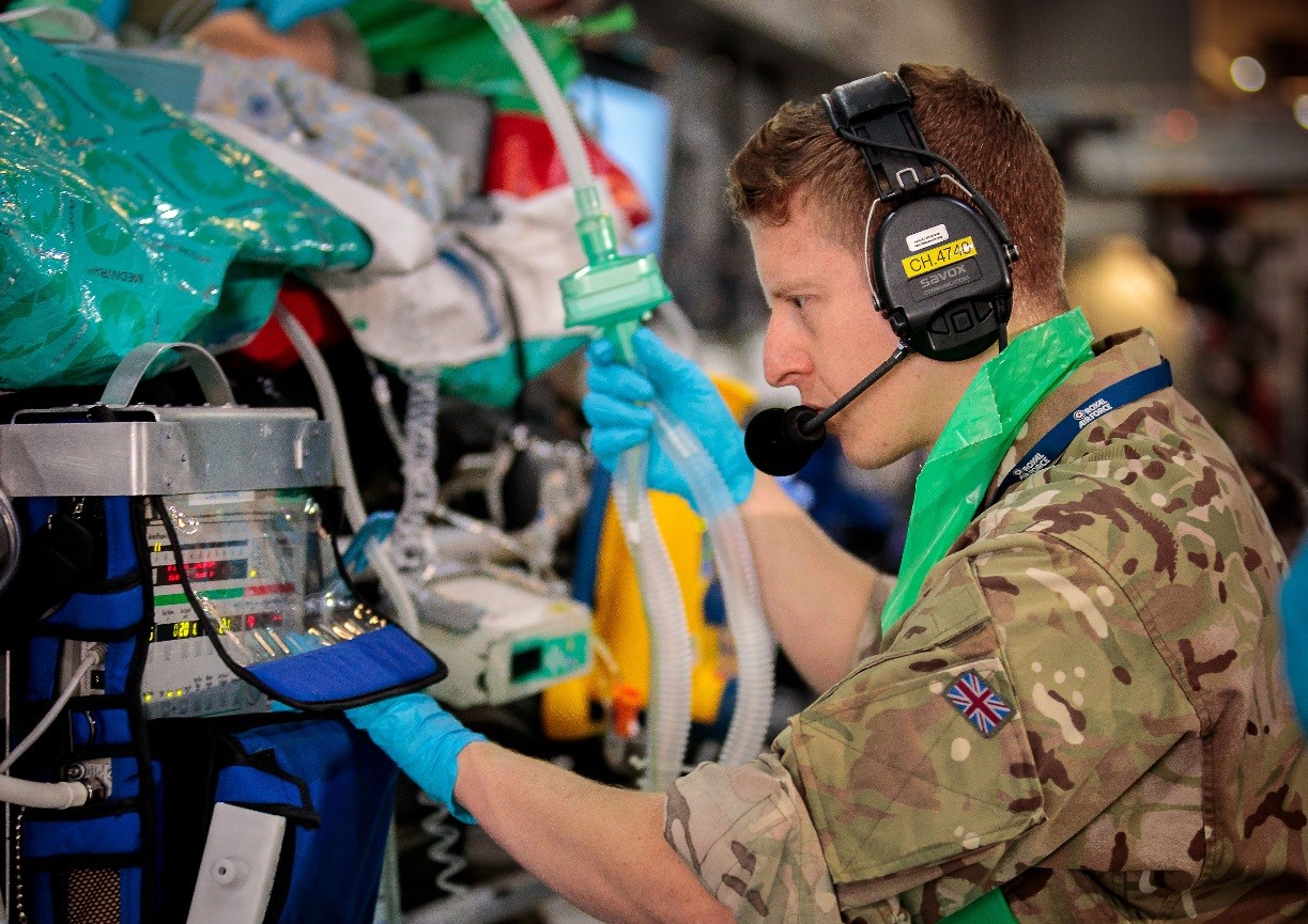 Flight Sergeant Andrews wearing a headset while working with equipment for critical care.