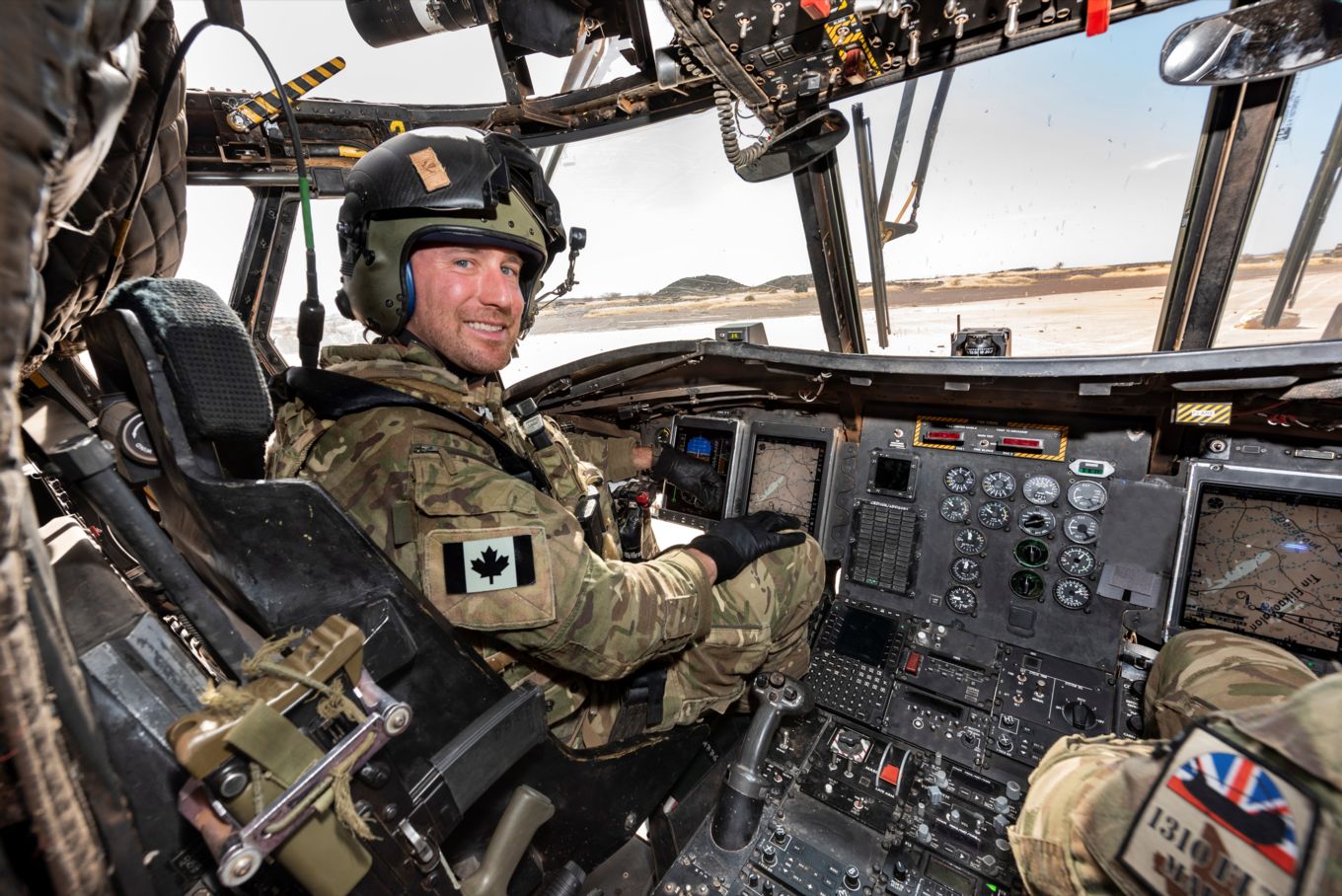 Image shows Captain Stewart in the cockpit of a Chinook helicopter.