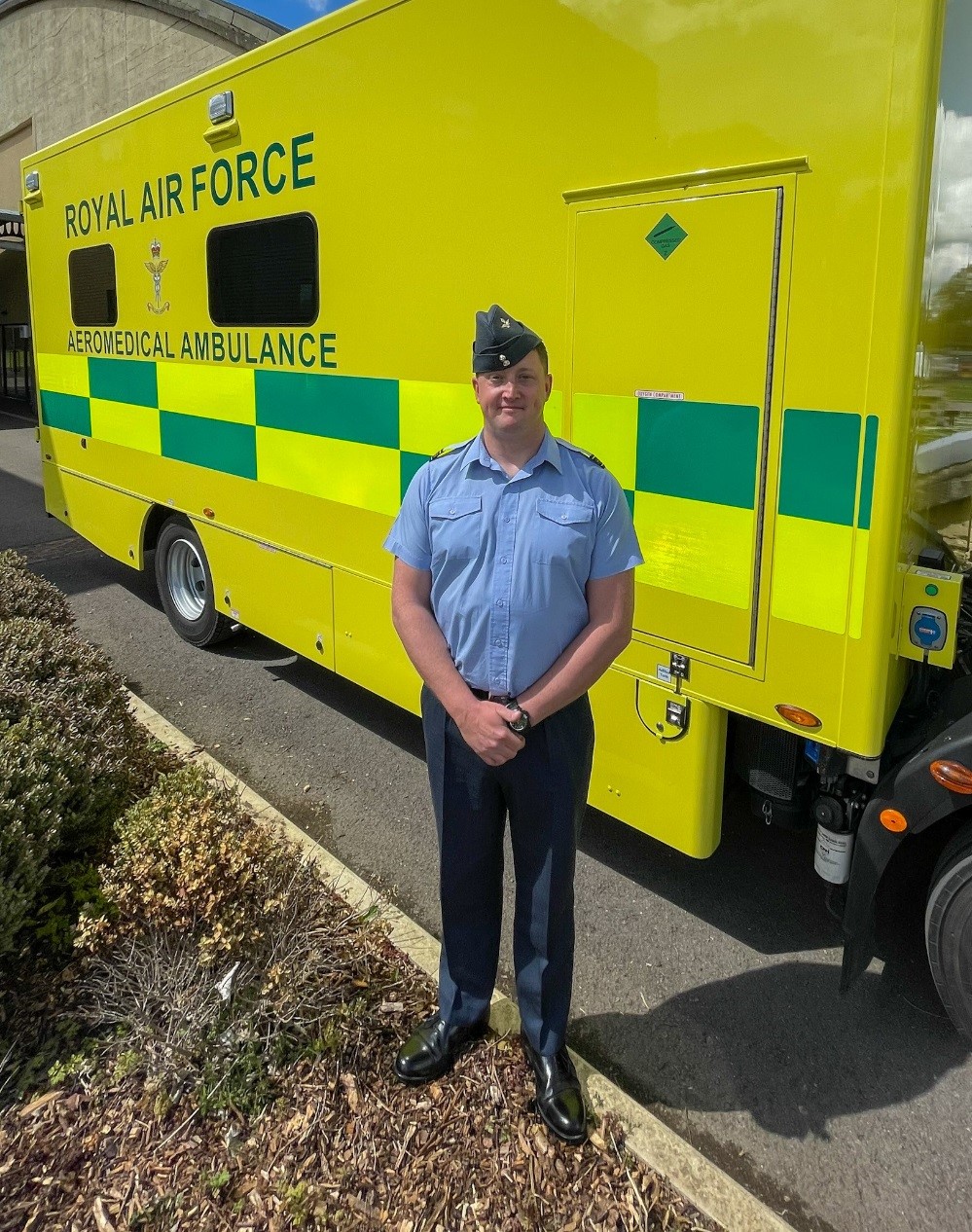 Squadron Lead Green stands in-front of an Aeromedical Evacuation service ambulance.