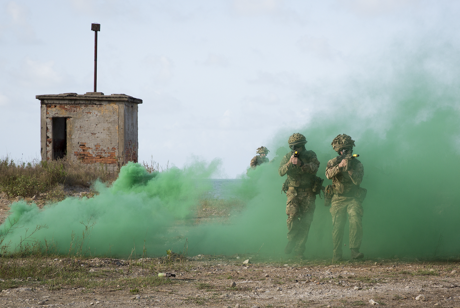 Personnel with a green smoke flare in the background