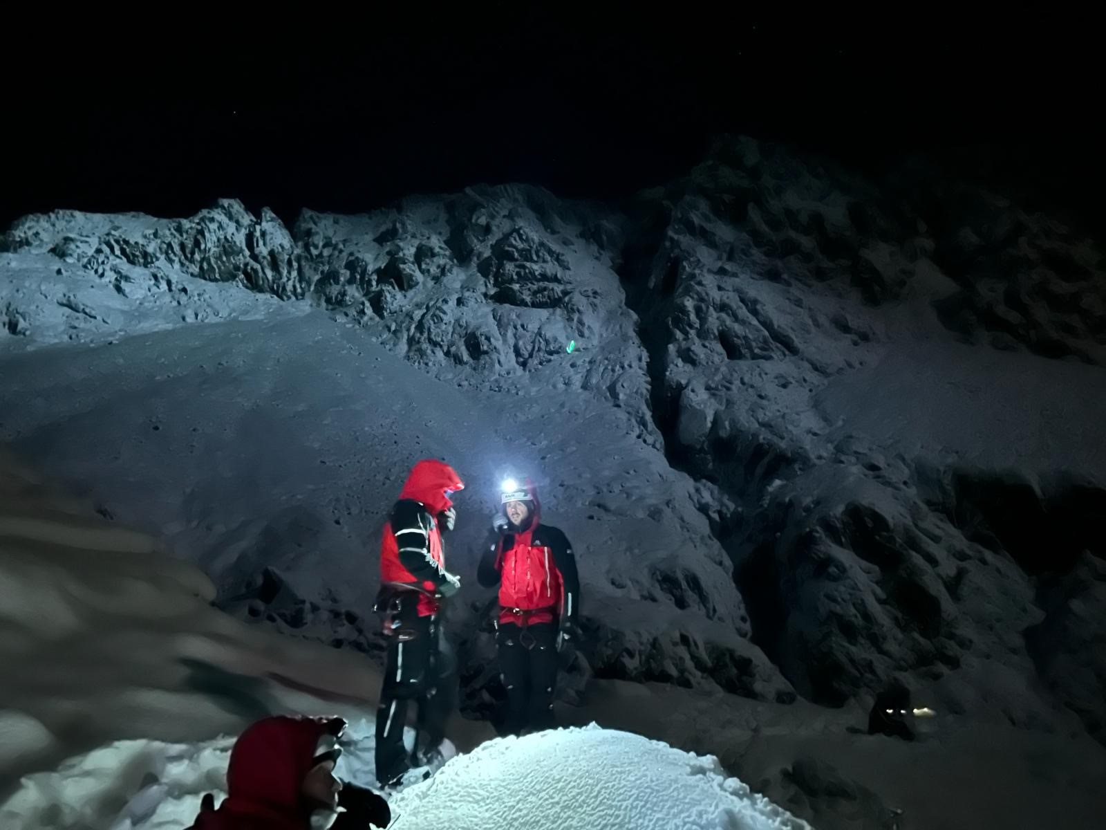 Two team members at night in the snow