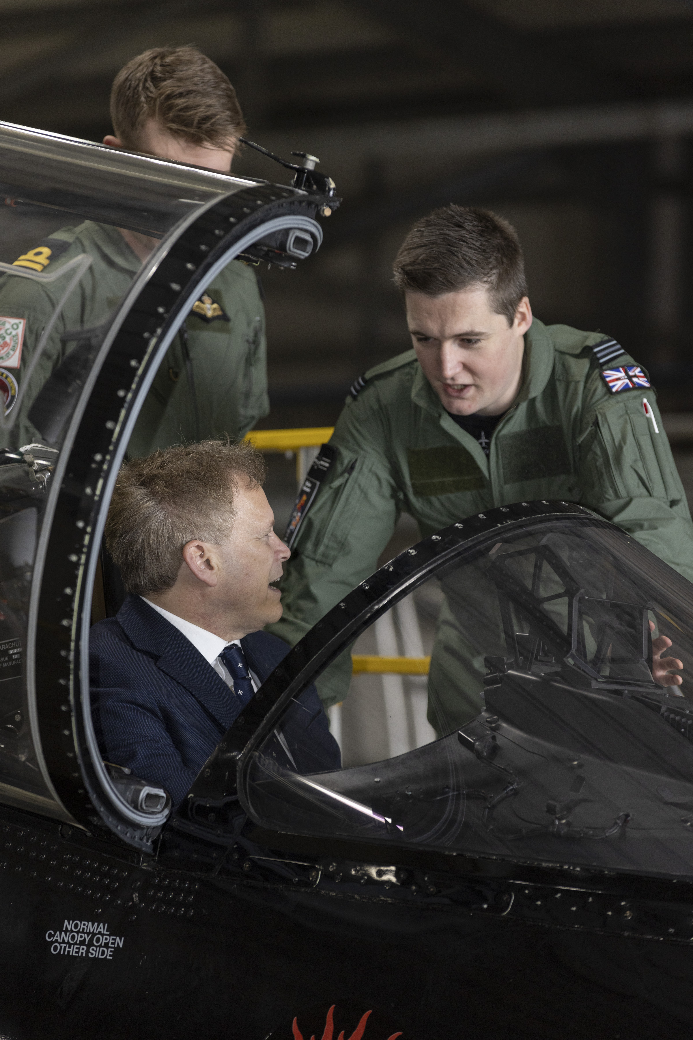 Defence Secretary chatting to personnel whilst sitting in an aircraft cockpit