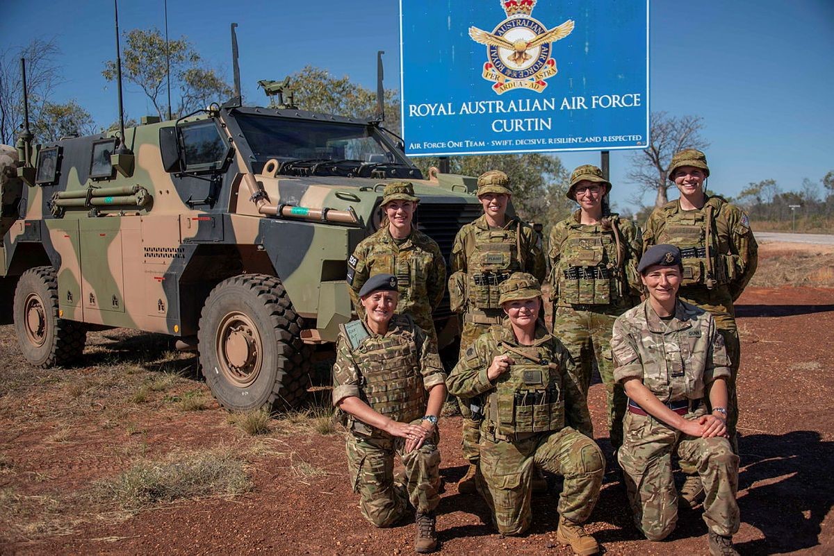 RAF chefs outside the sign for the RAAF base