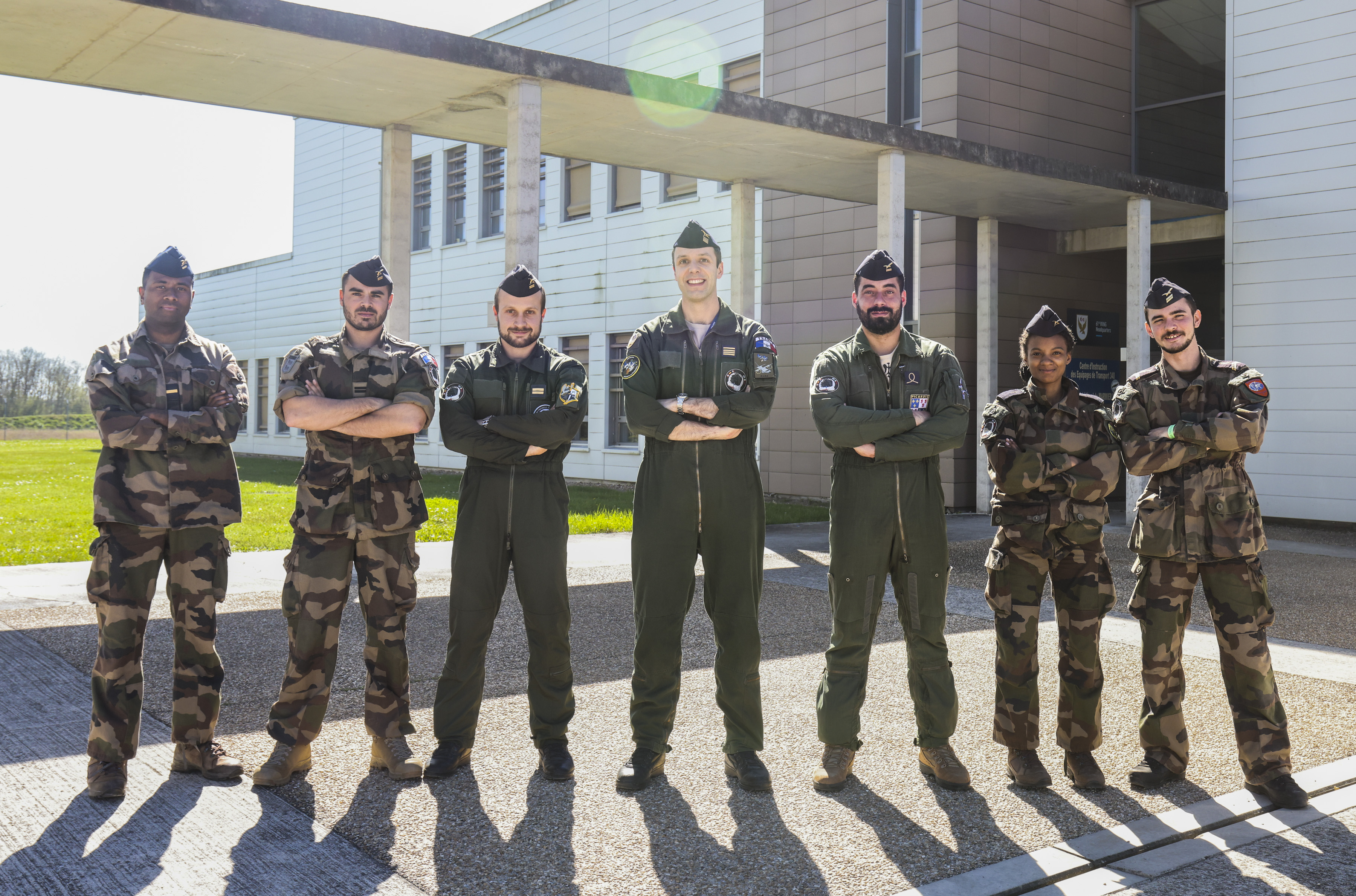 Personnel from the different Air Forces standing smiling at the camera with their arms crossed
