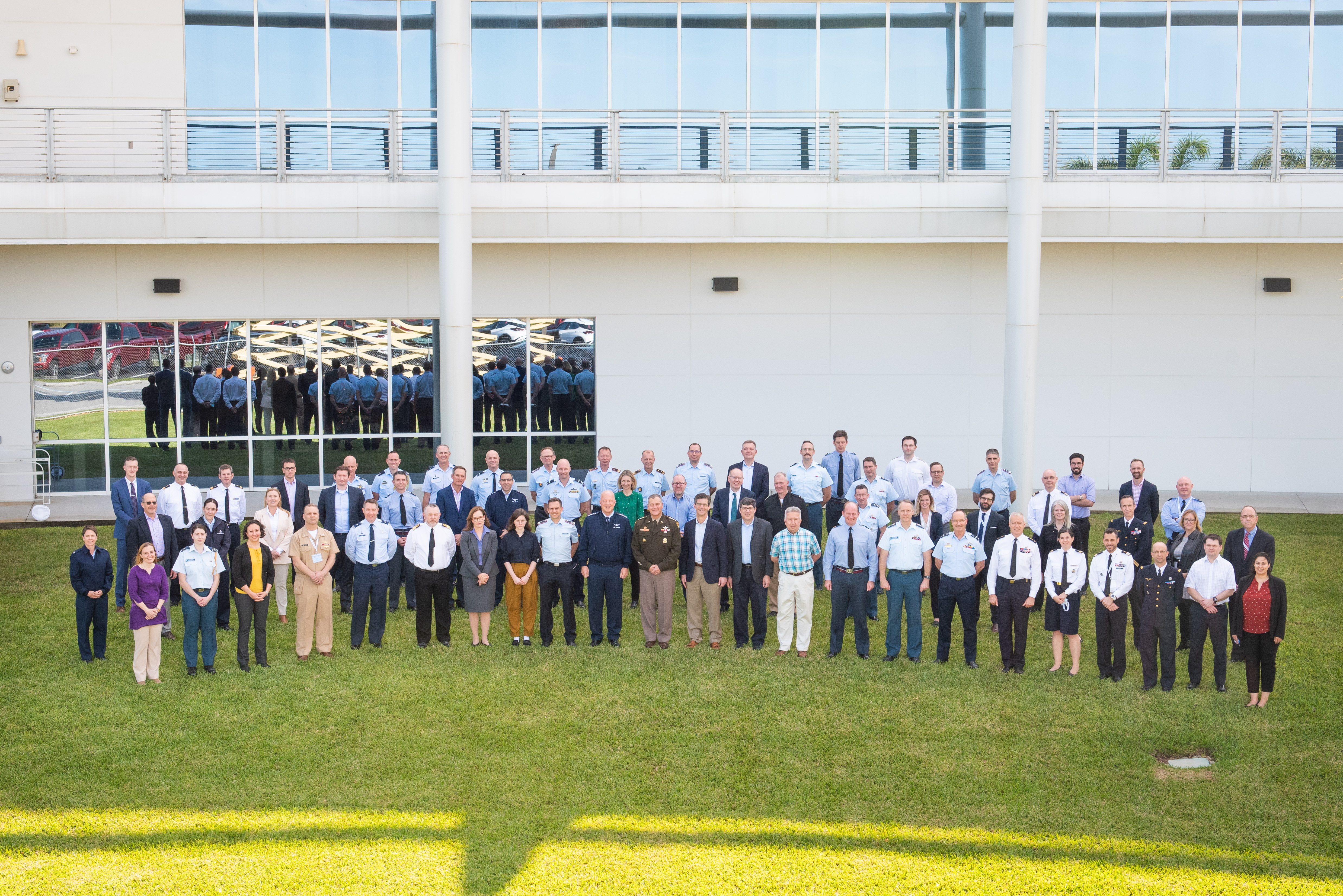 Personnel group standing outside building.