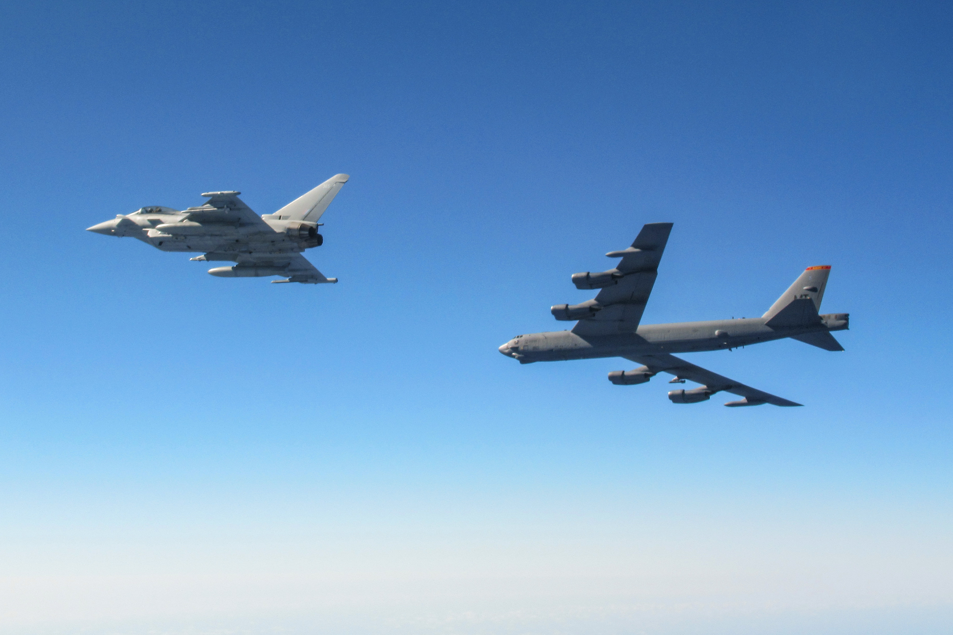 Image shows a RAF Typhoon and B-52 Stratofortresses.