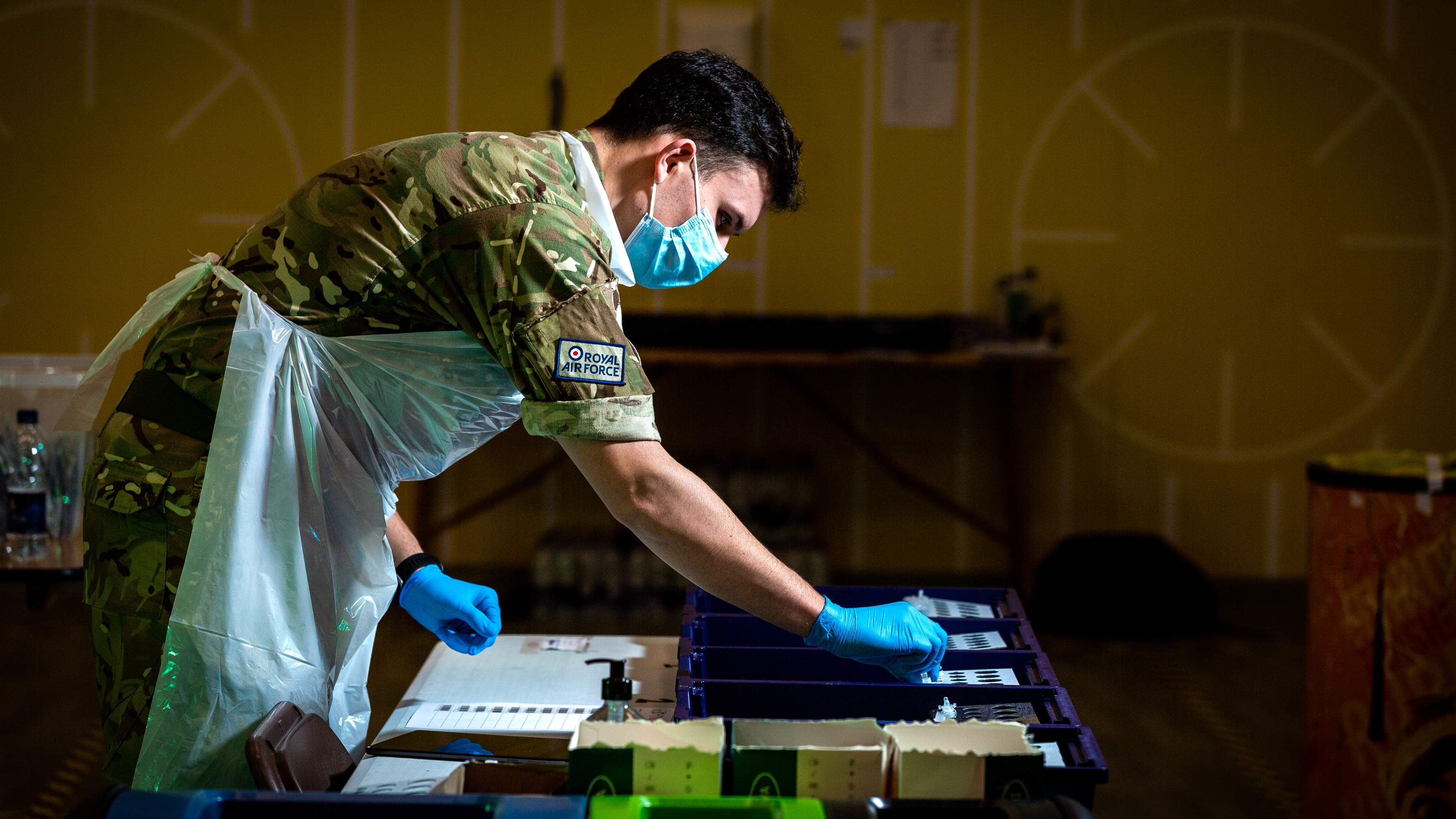 Personnel stands over vaccines. 