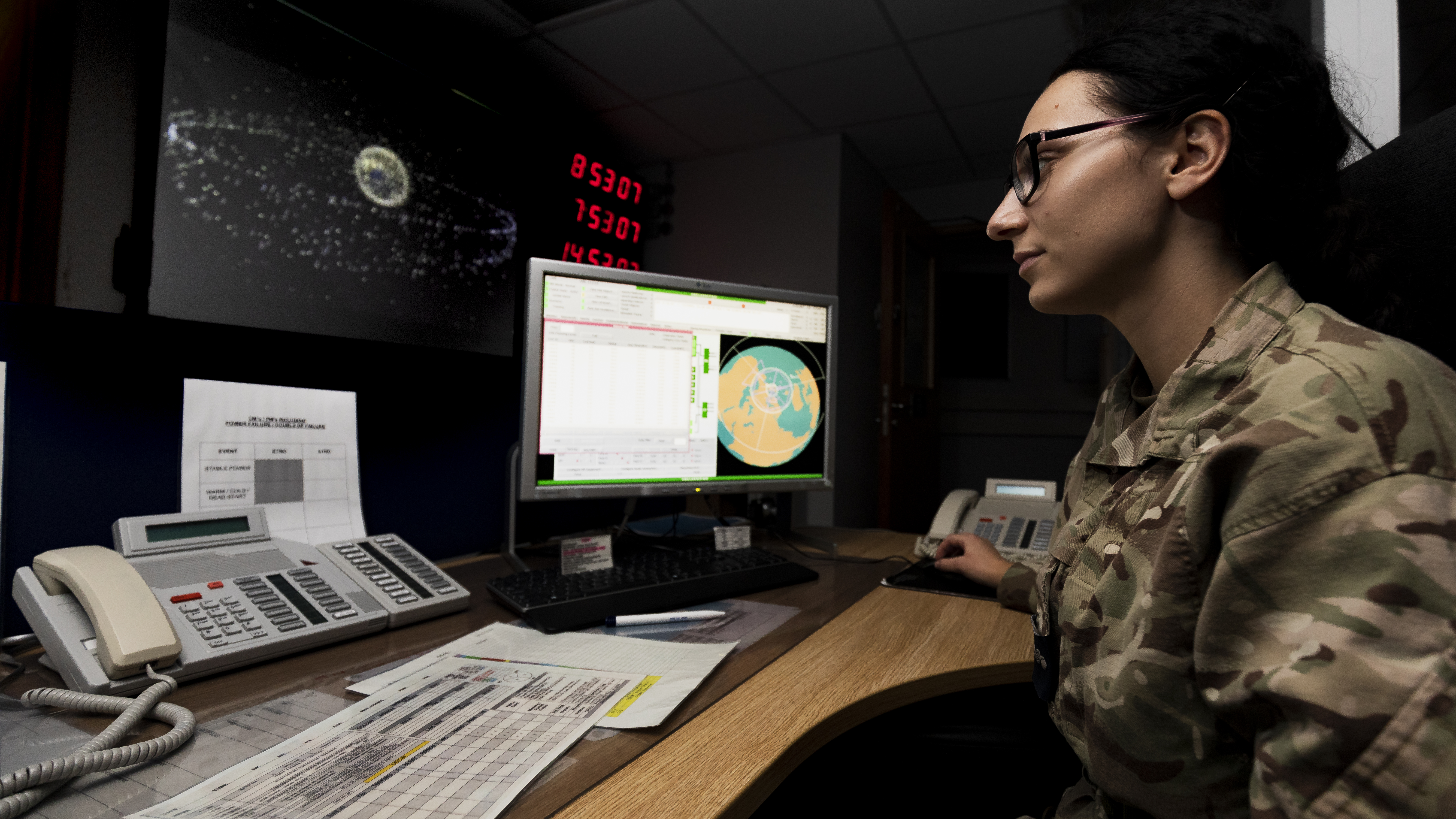 Personnel works at desk with computers.