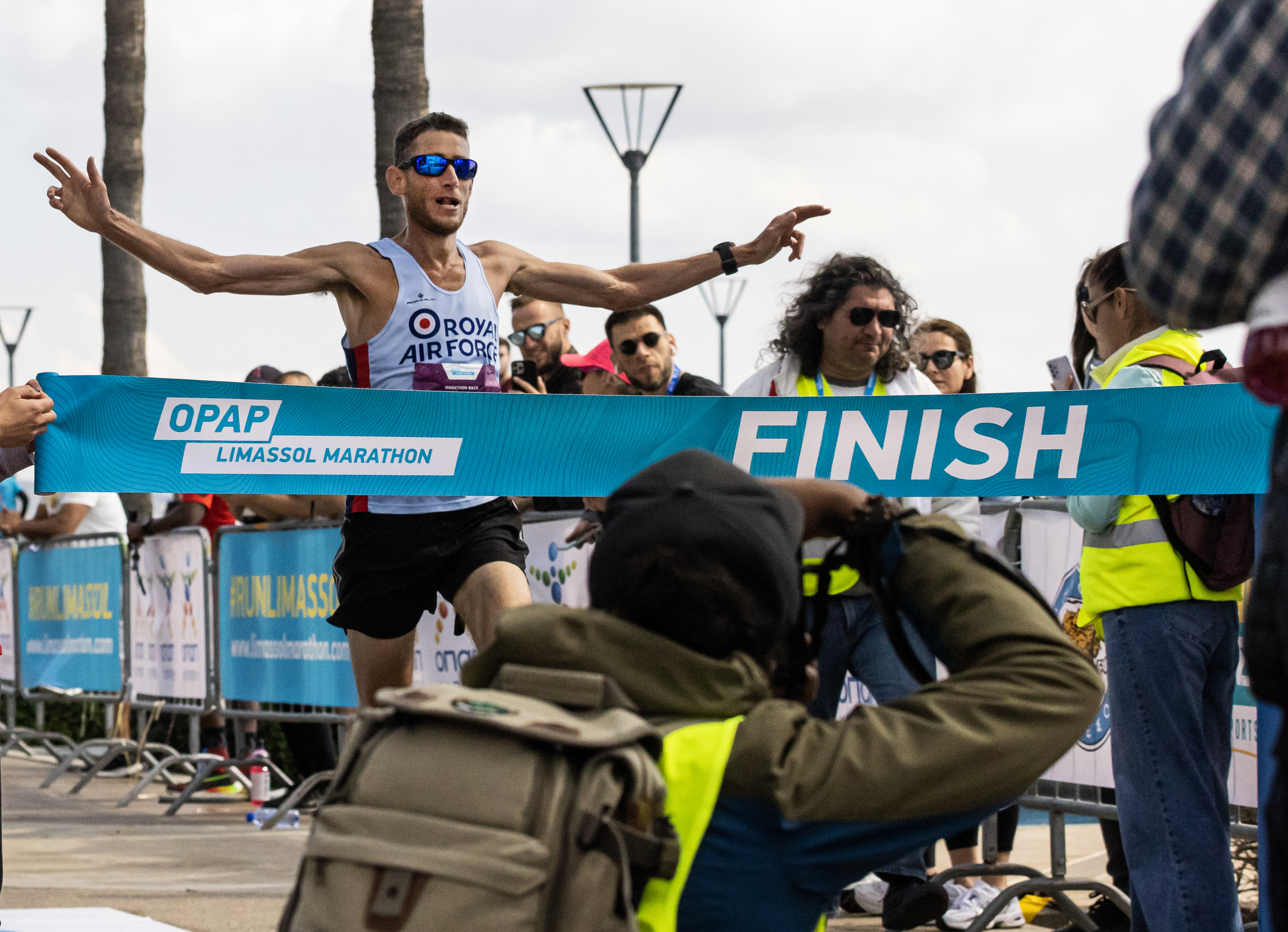 Image shows RAF personnel running towards the Marathon finishing line.
