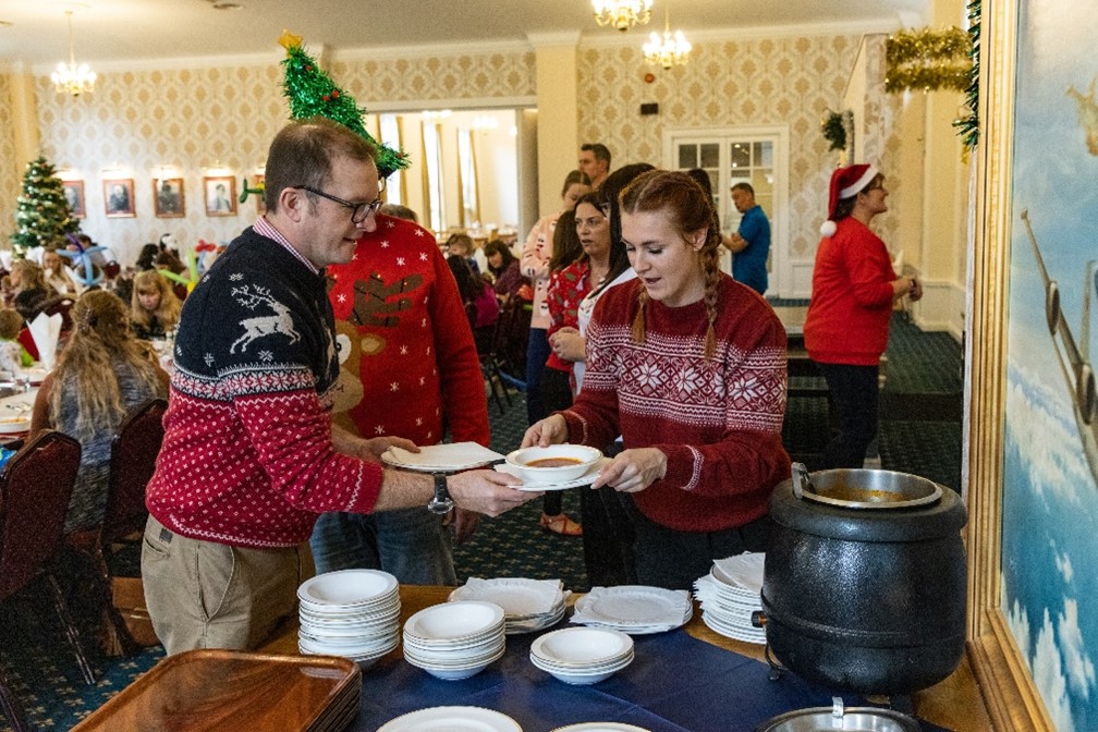 Image shows families serving themselves soup.