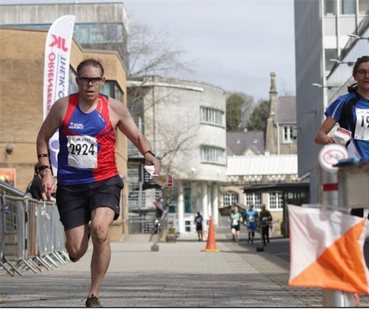 Orienteer runs through the streets before spectators.