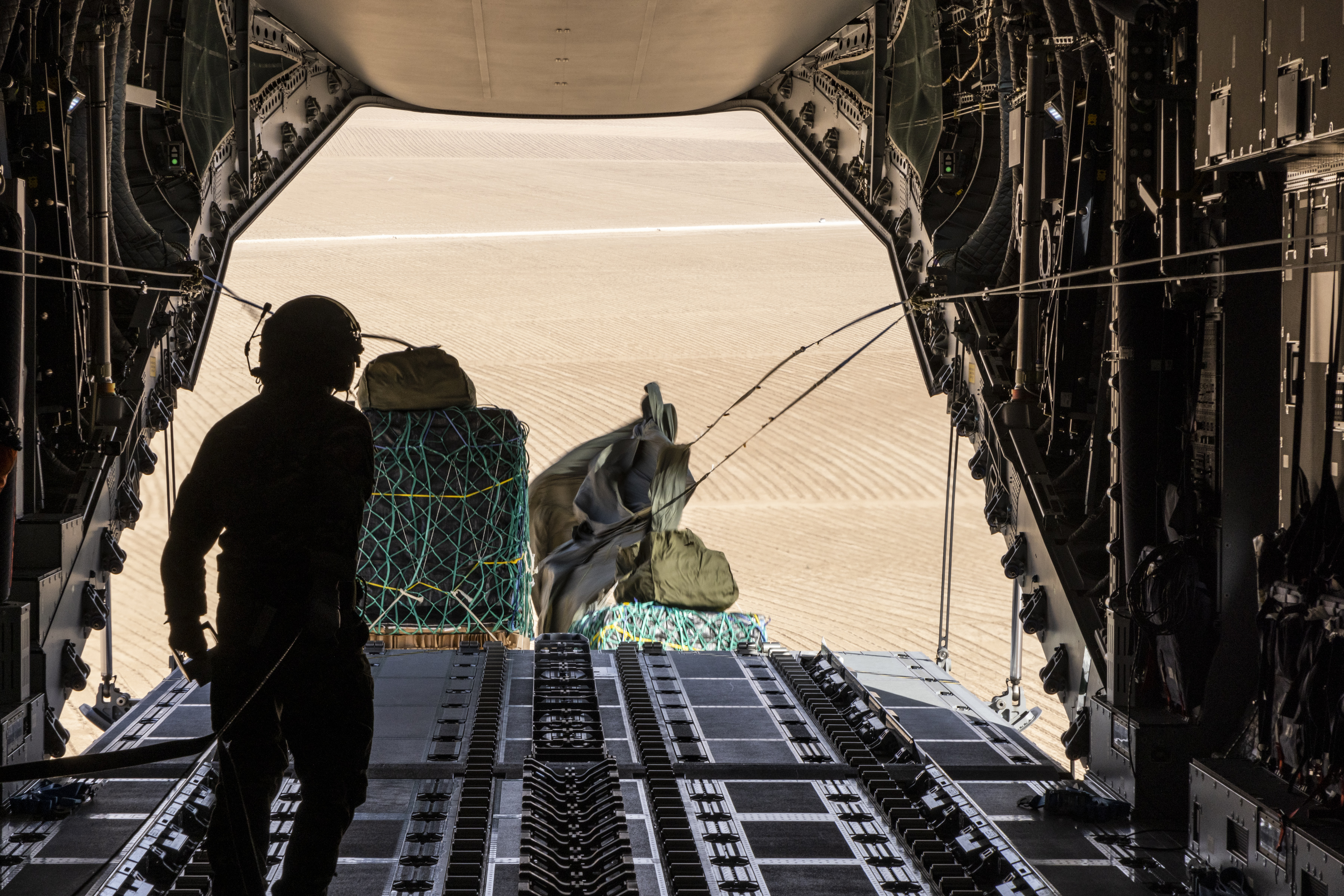 Image shows the open end of the Atlas loading bay with RAF aviators dropping cargo.