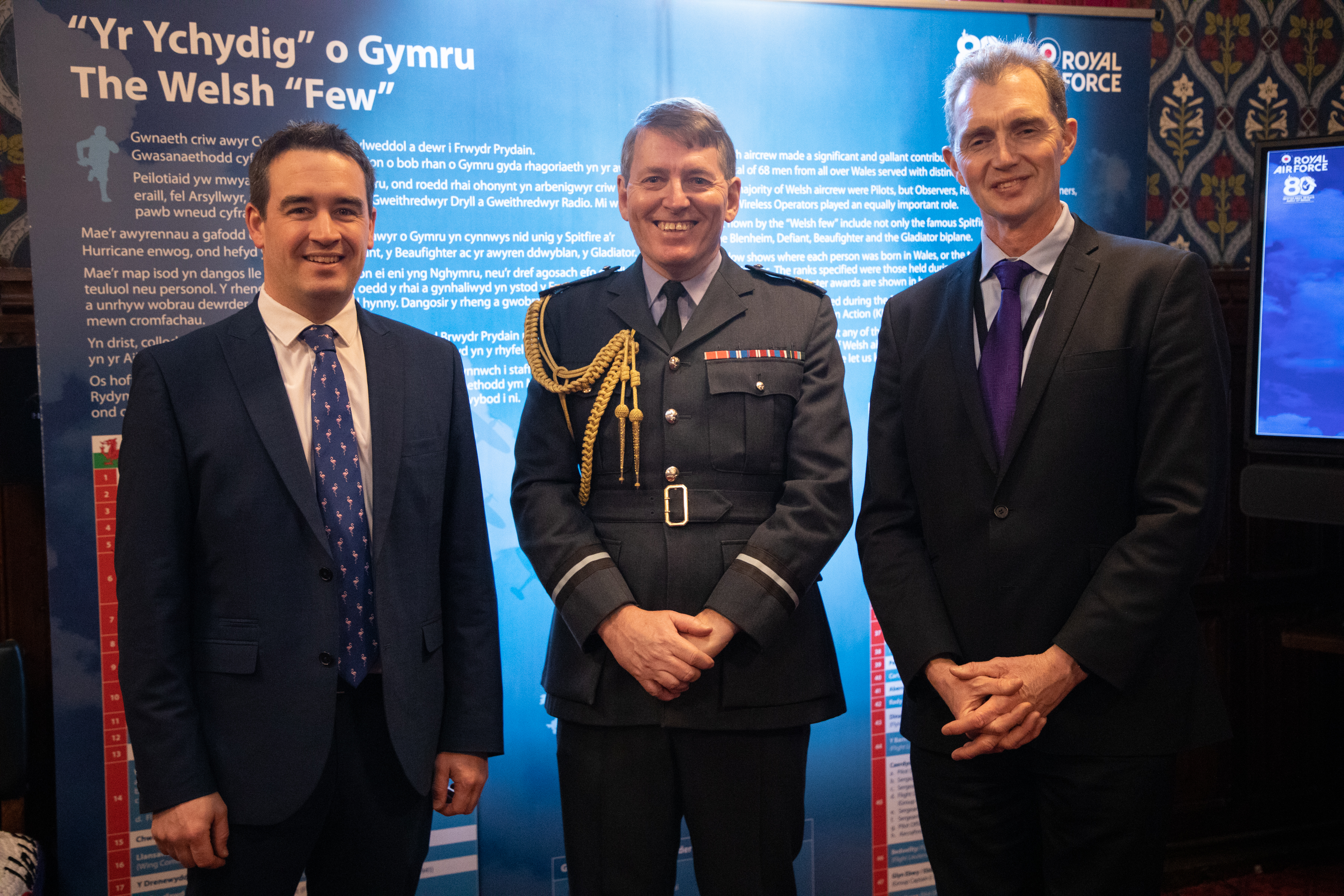 Image shows RAF aviator and civilians smiling at exhibition.