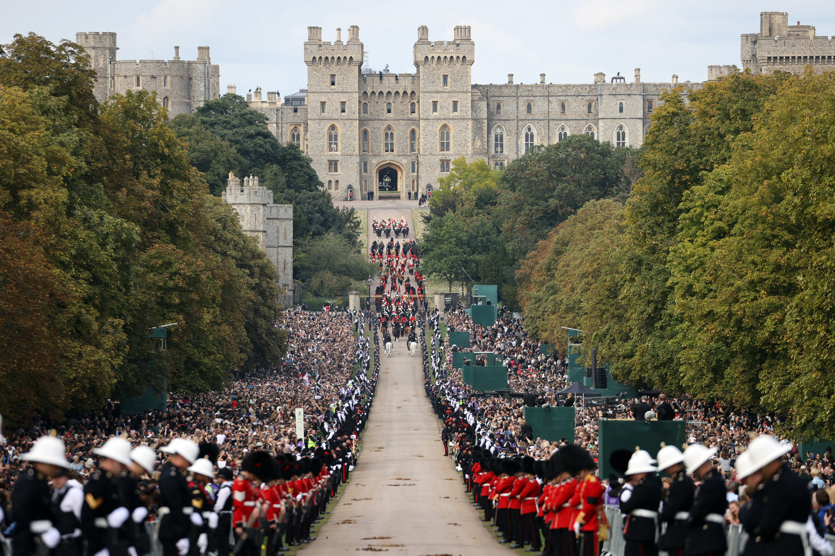 Image shows the Armed Forces parading up the Mall towards Buckingham Palace.