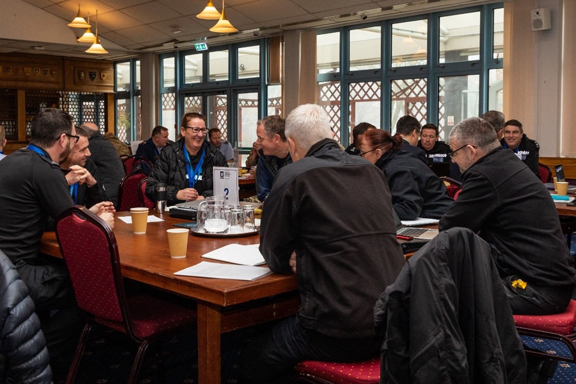 Image shows RAF aviators and local police sitting around tables.