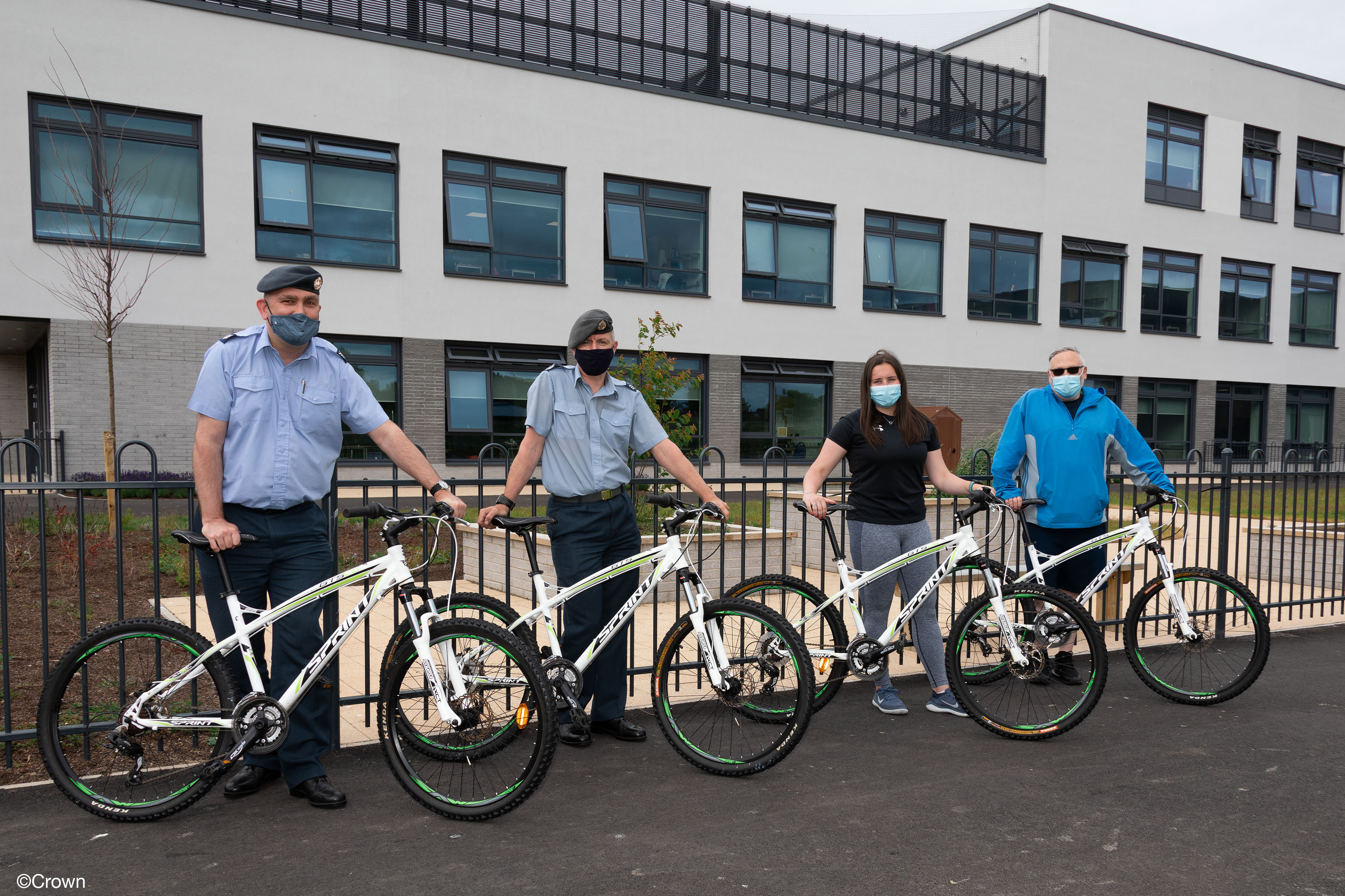 Personnel stand with bicycles.