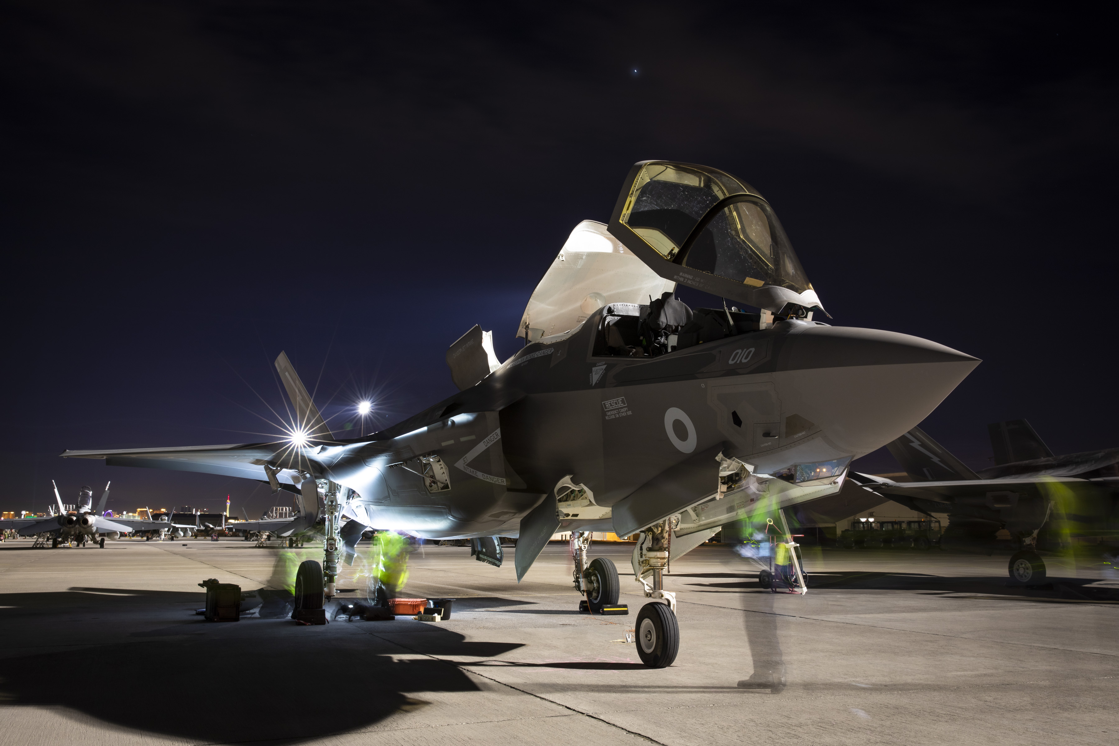 Image shows RAF Typhoon on the airfield with blurred RAF pilots standing by it.
