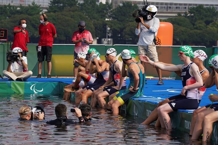 Triathletes get ready to enter the water for the swim part of the race.