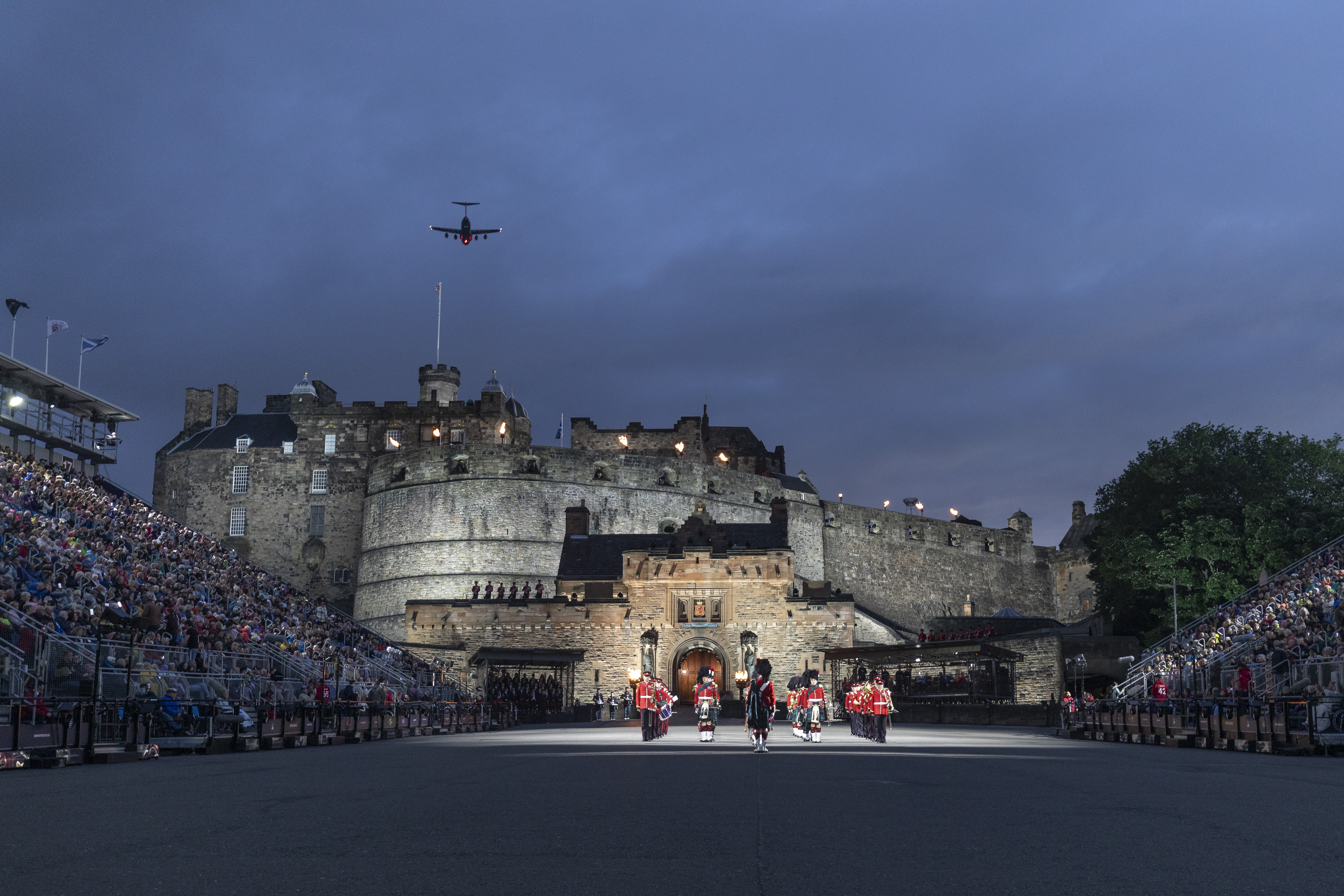 Image shows musicians outside Edinburgh Castle, with crowds and a flypast.