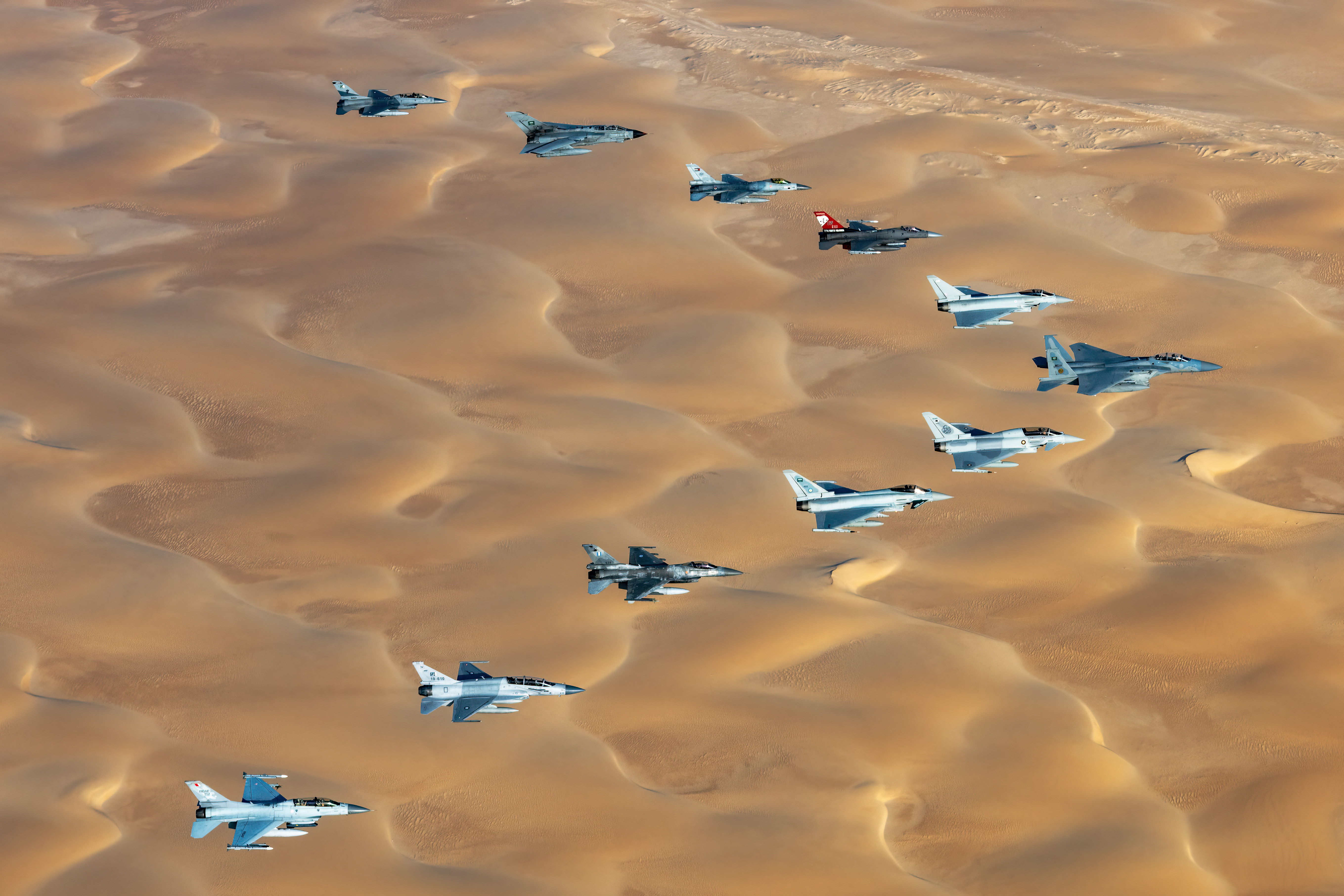 Image shows RAF Typhoons flying in formation over the desert.