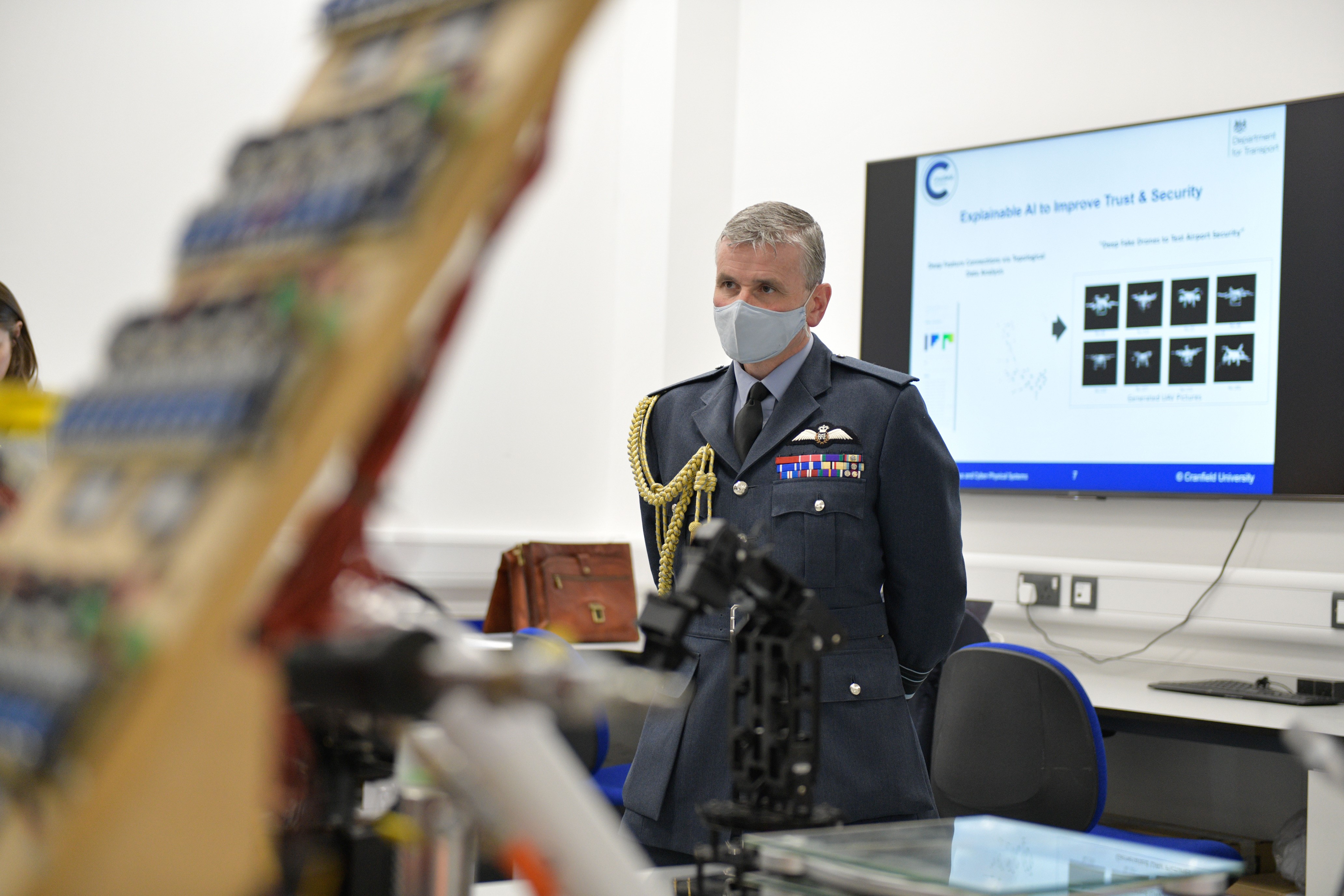 Air Marshal Turner standing before presentation screen.