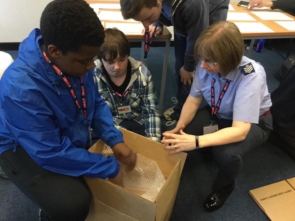 Image shows aviator interacting with school pupils.