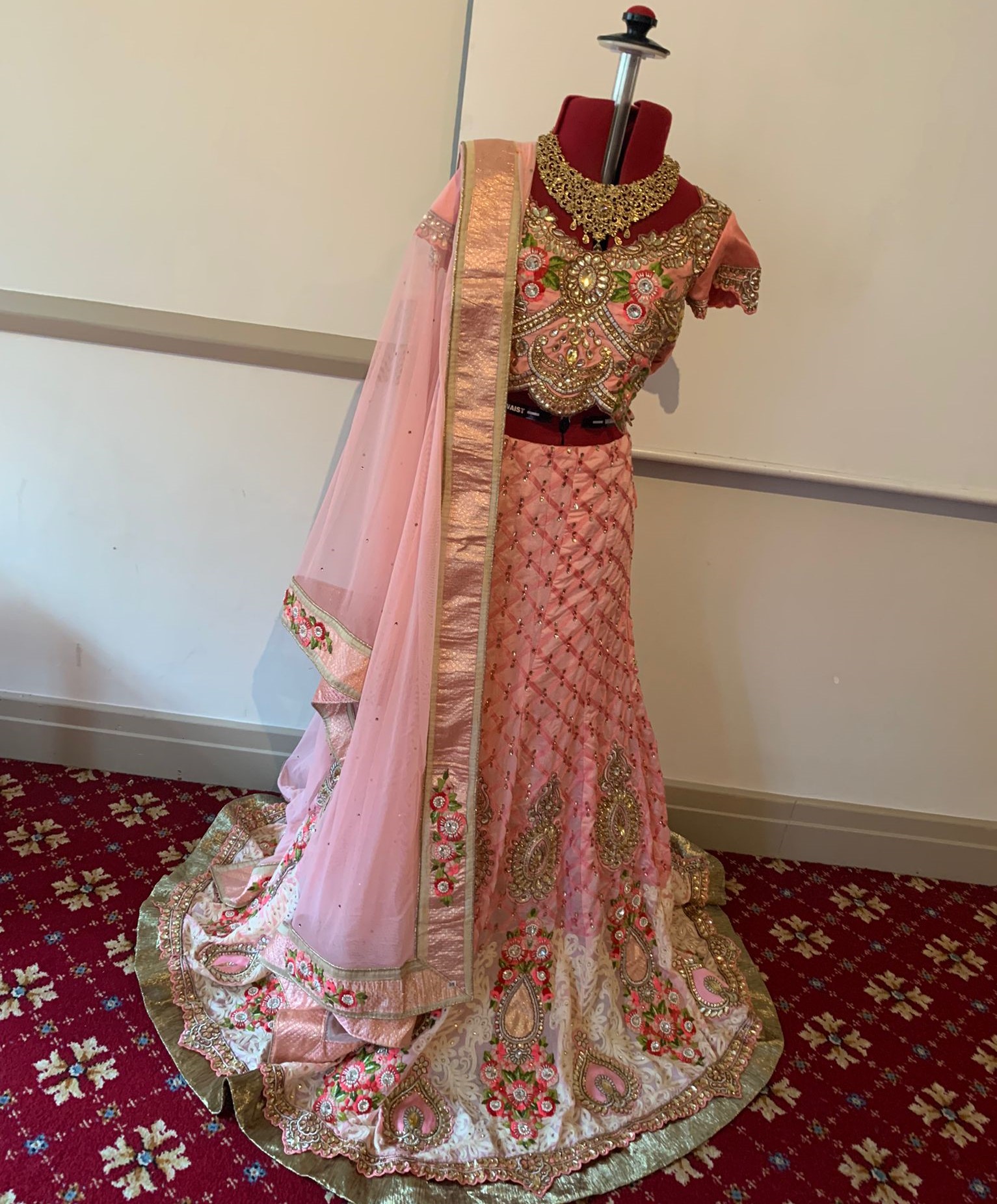 Image shows a traditional sari dress on tailor a mannequin.