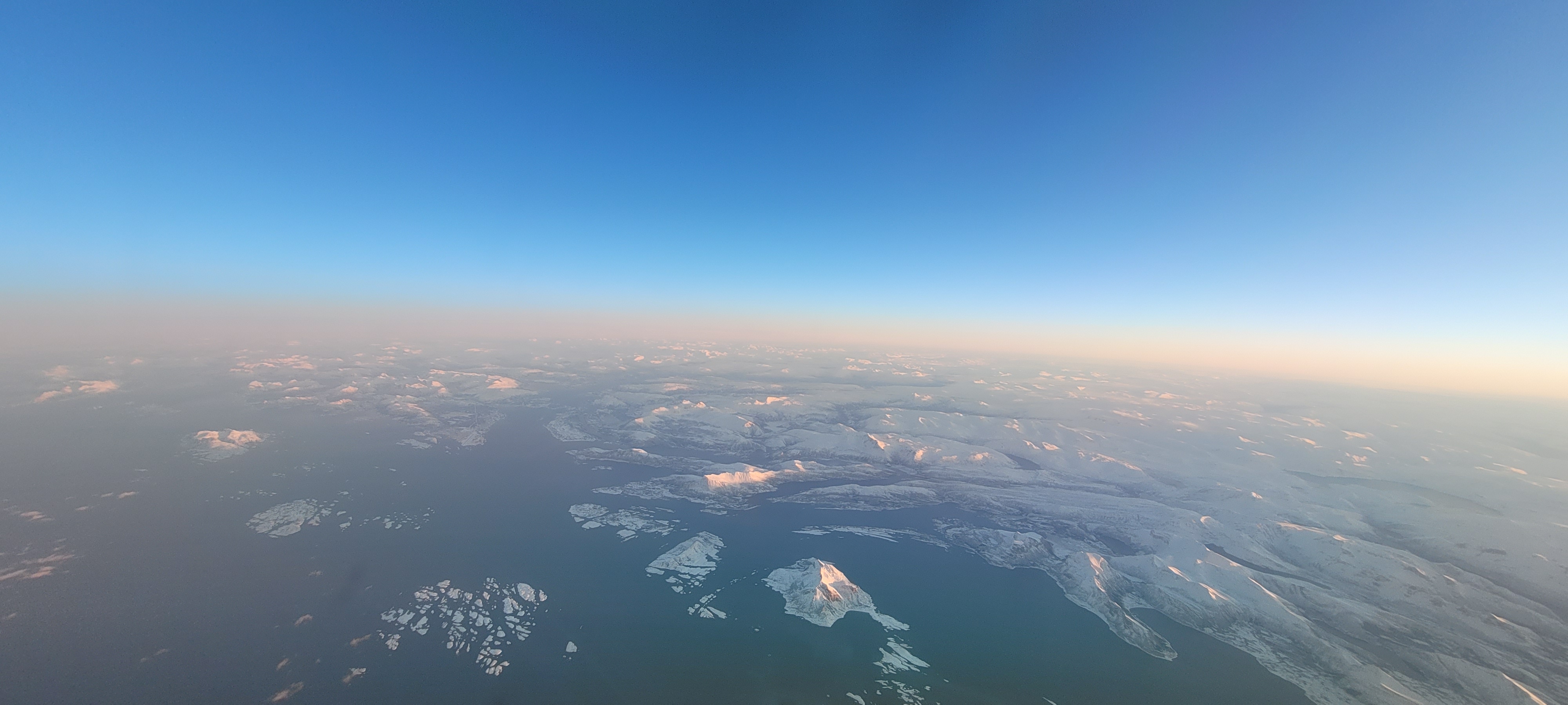 Blue skies and clouds above the snowy mountain ground.