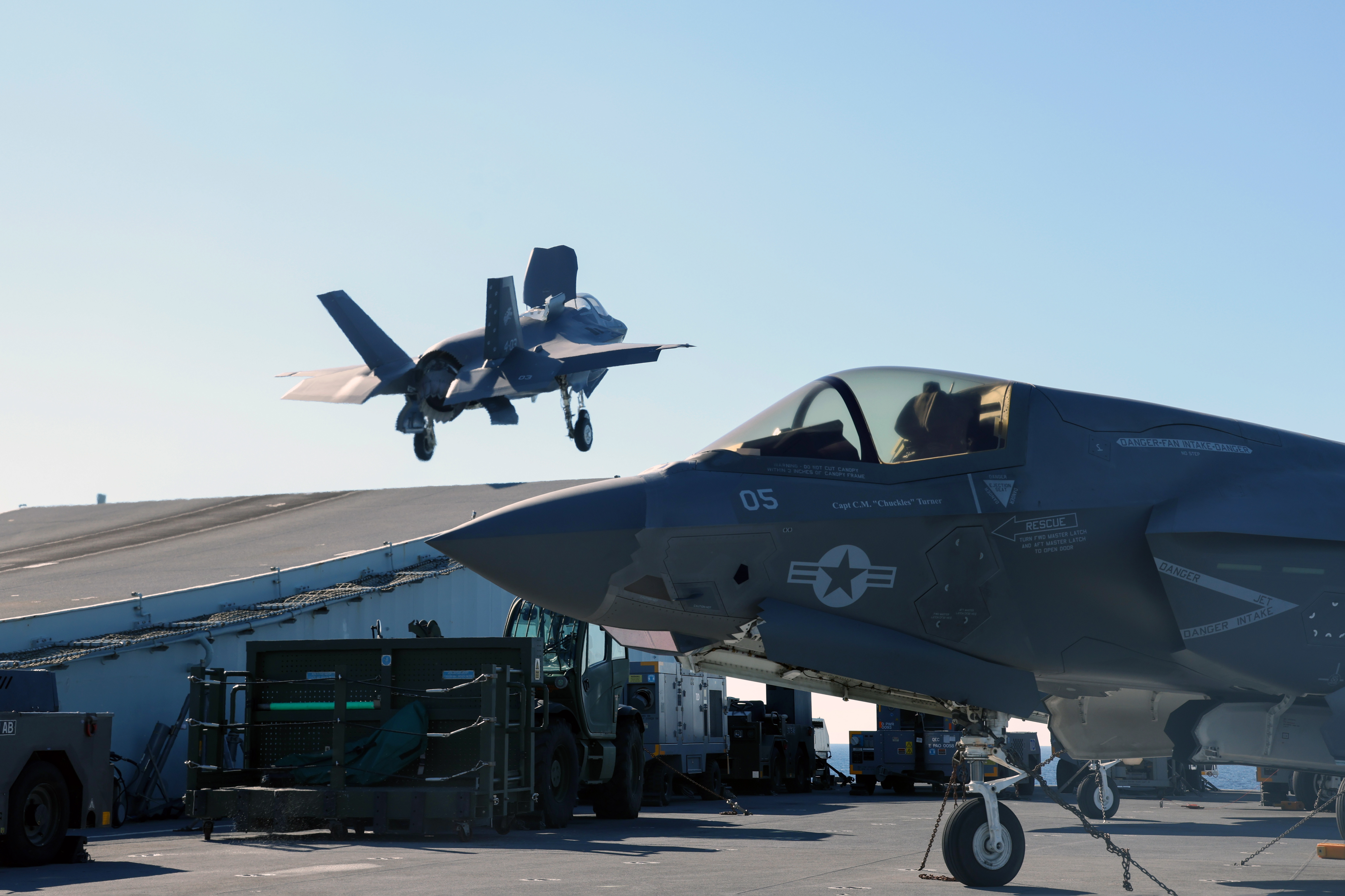 Aircraft on the carrier and one taking off.