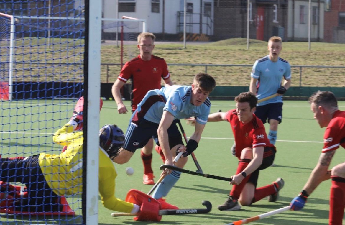 Image shows hockey players by the goal during a game.