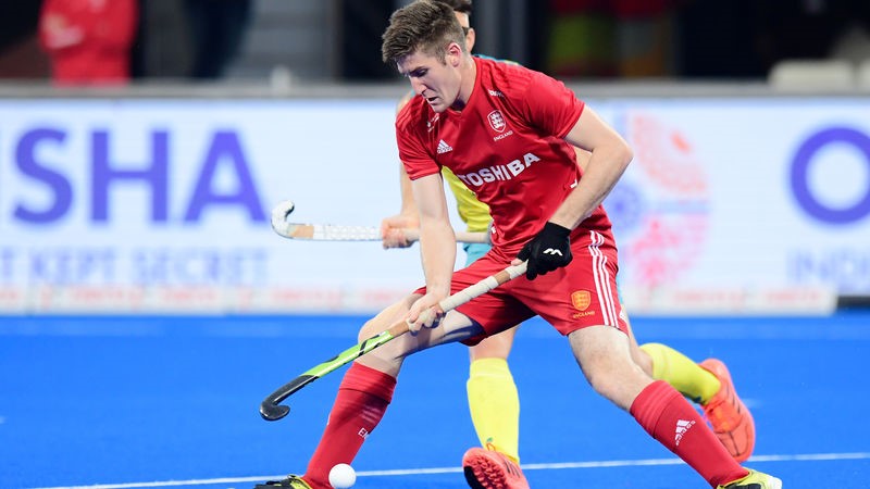 Image shows hockey players on the pitch during a game.