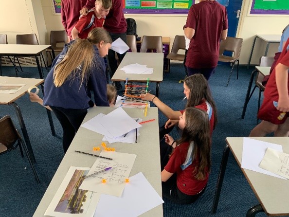 Image shows school pupils building their models on tables.