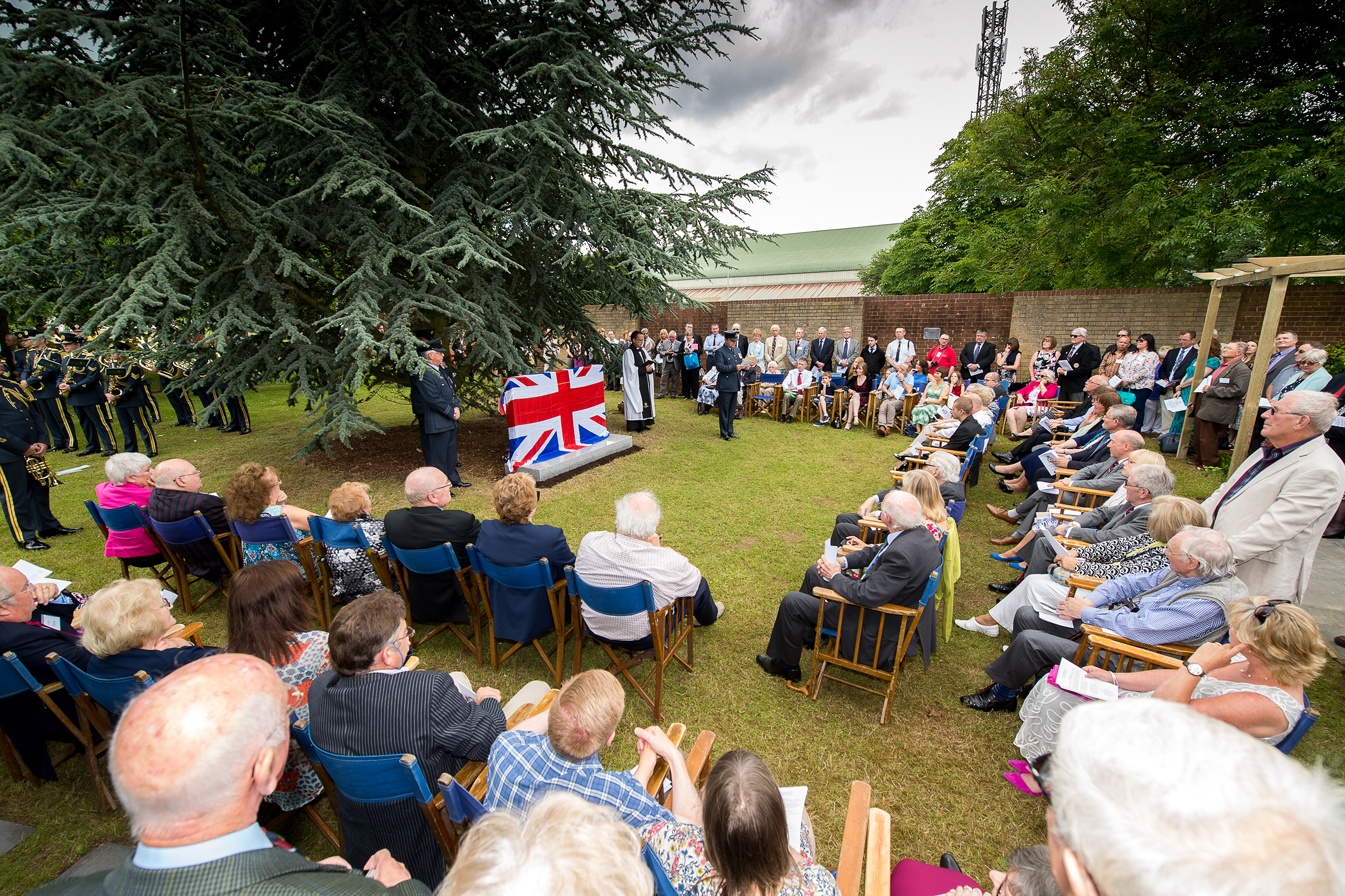 Personnel and members of the public at service by memorial.