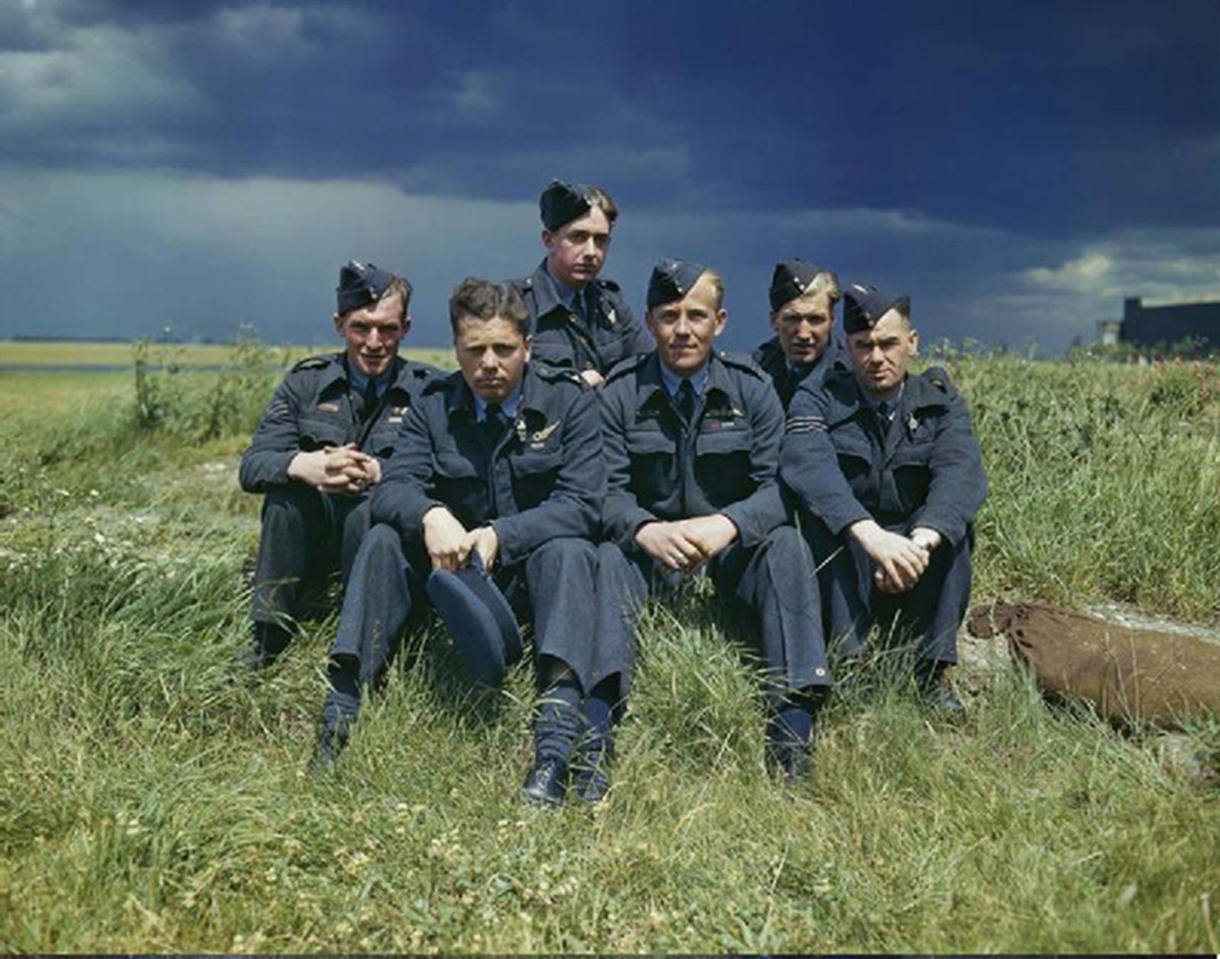 Aviators sit on the grass.