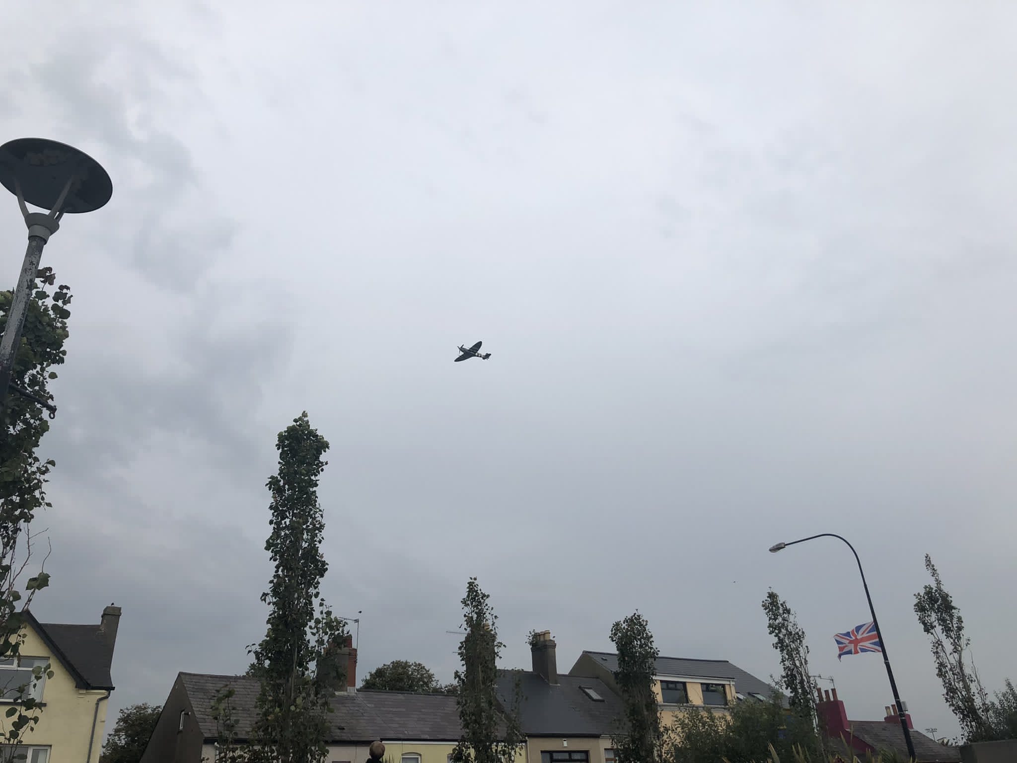 Spitfire Mk Vb AB910 flying over housing.