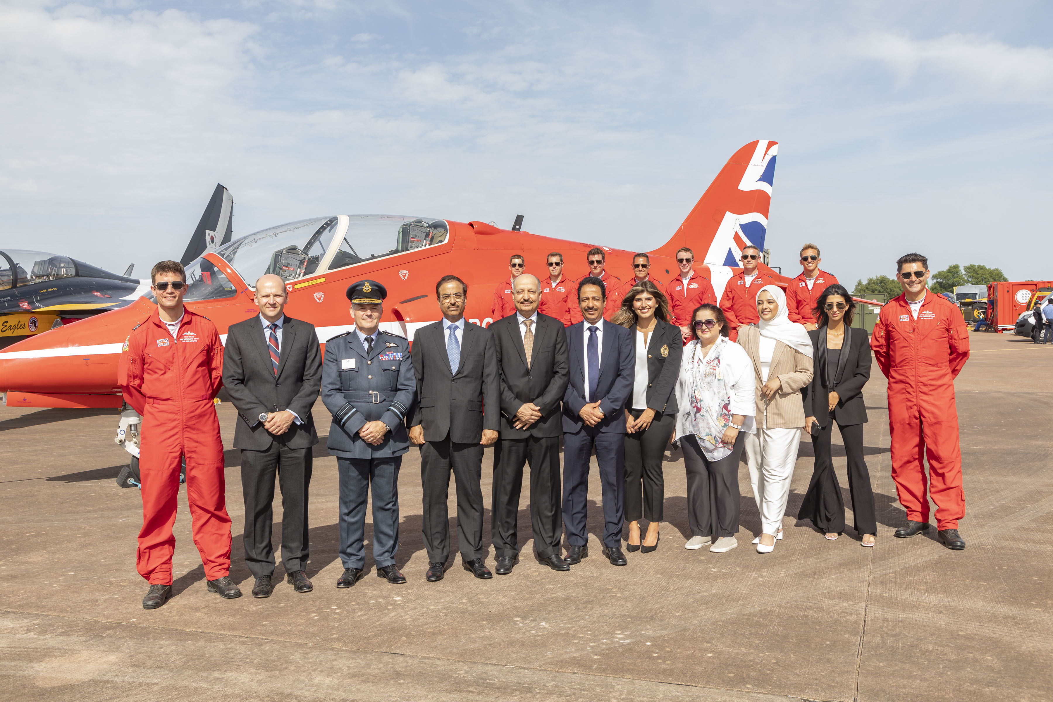 Images shows the Red Arrows with aviators. Hawk T2 aircraft in the background.