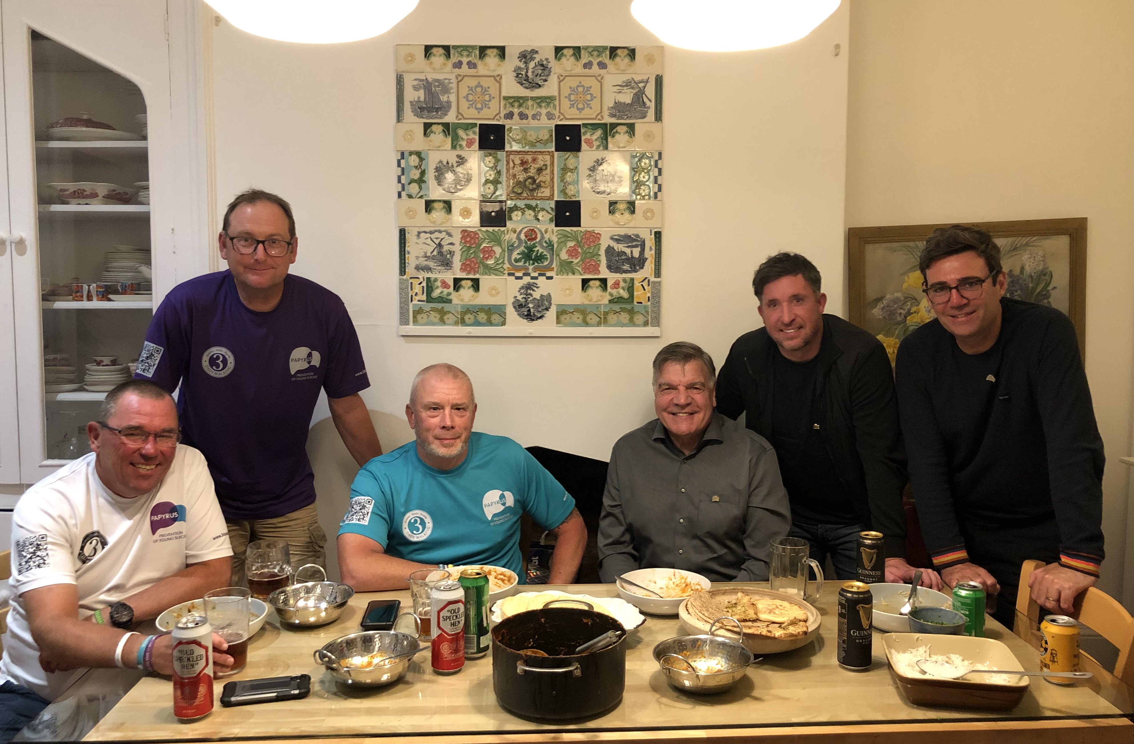 Image shows a group sitting at the table with their Indian takeaway.