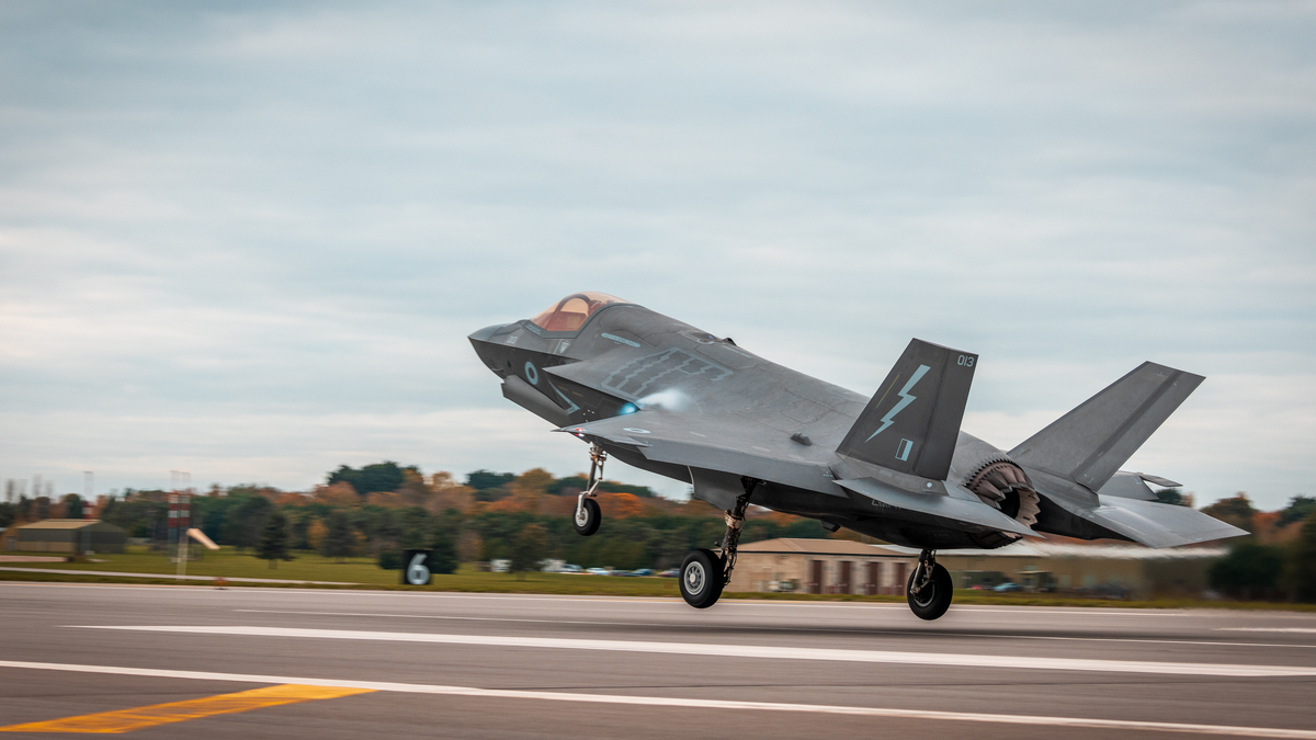 Image shows Lightning aircraft taking off from airfield.