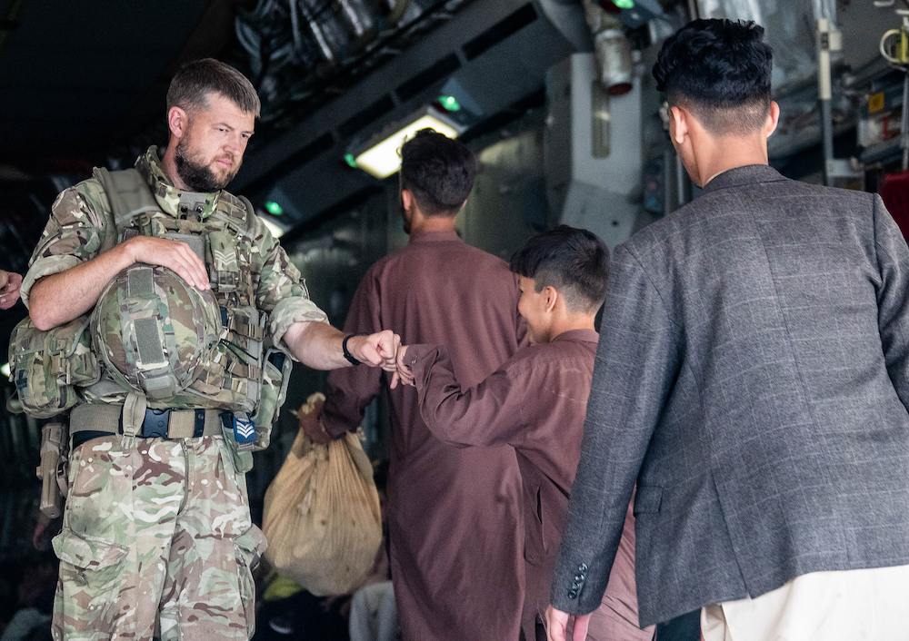 Personnel welcome Afghan refugees onto Globemaster.